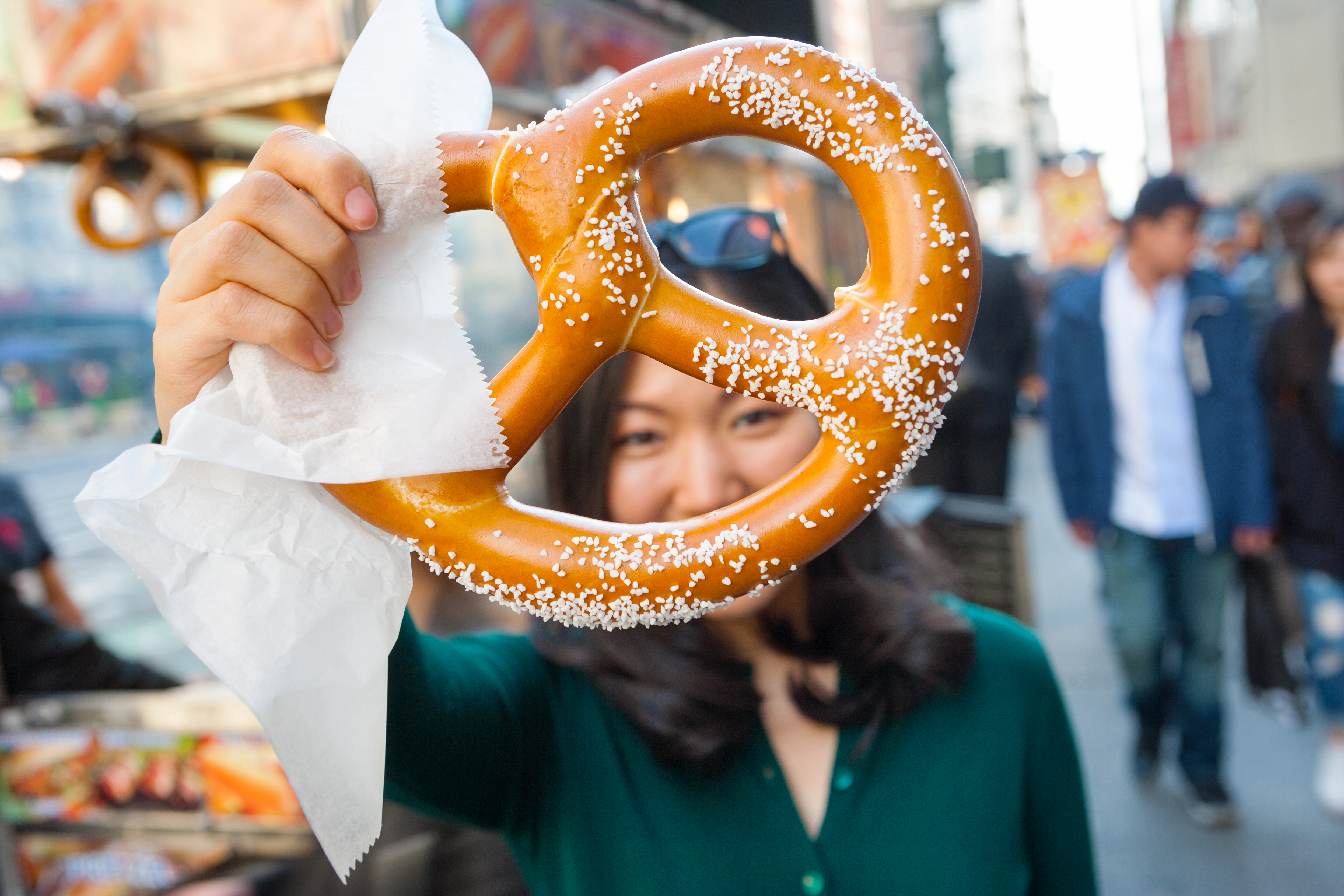 Woman holding a pretzel up to the camera