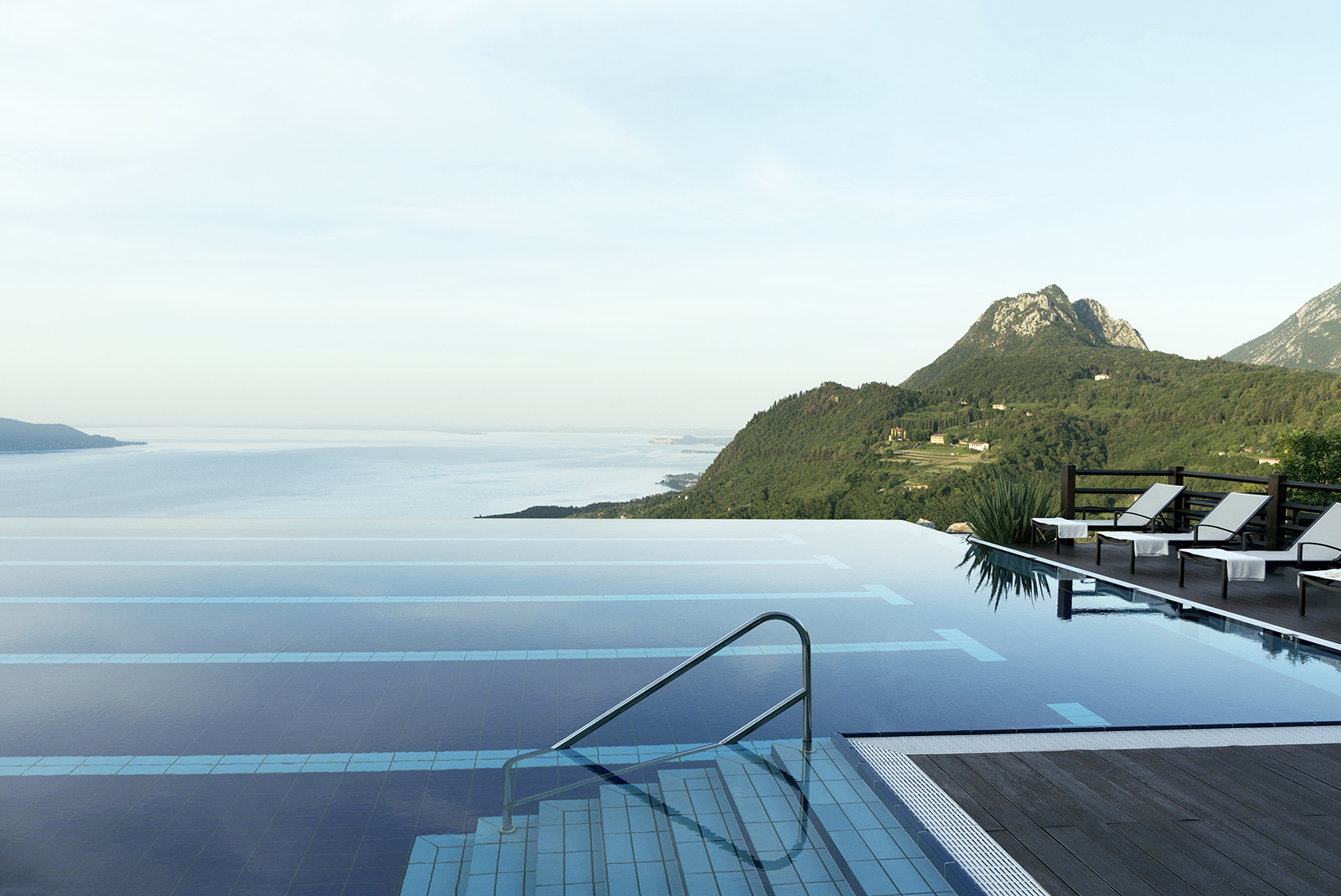 Europe, Italy, Lefay Resort & SPA Lago di Garda, outdoor infinity pool and sun loungers overlooking Lake Garda