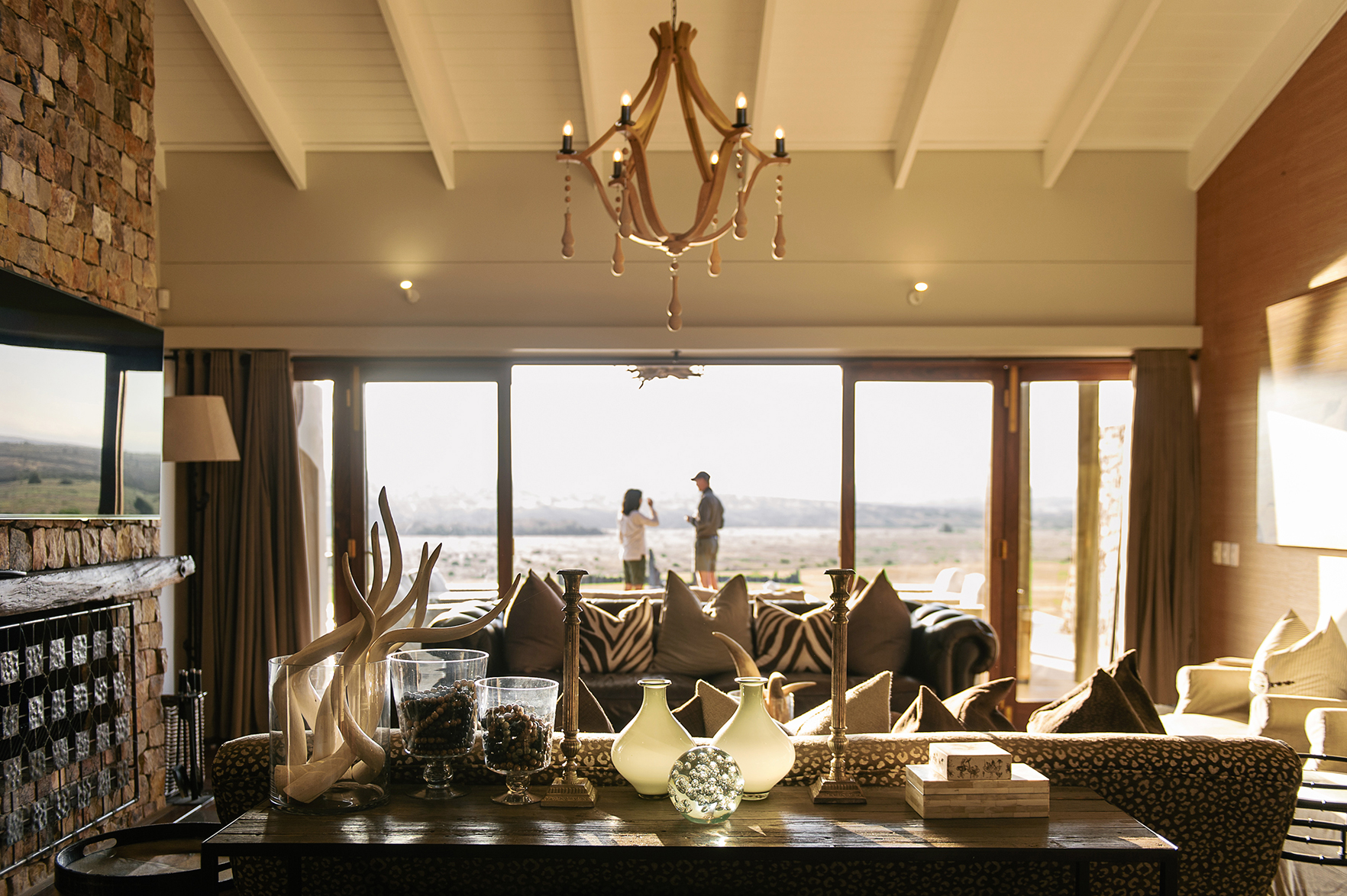 Africa, South Africa, Kwandwe Private Game Reserve Fort House, lounge area with two people in on the outdoor terrace