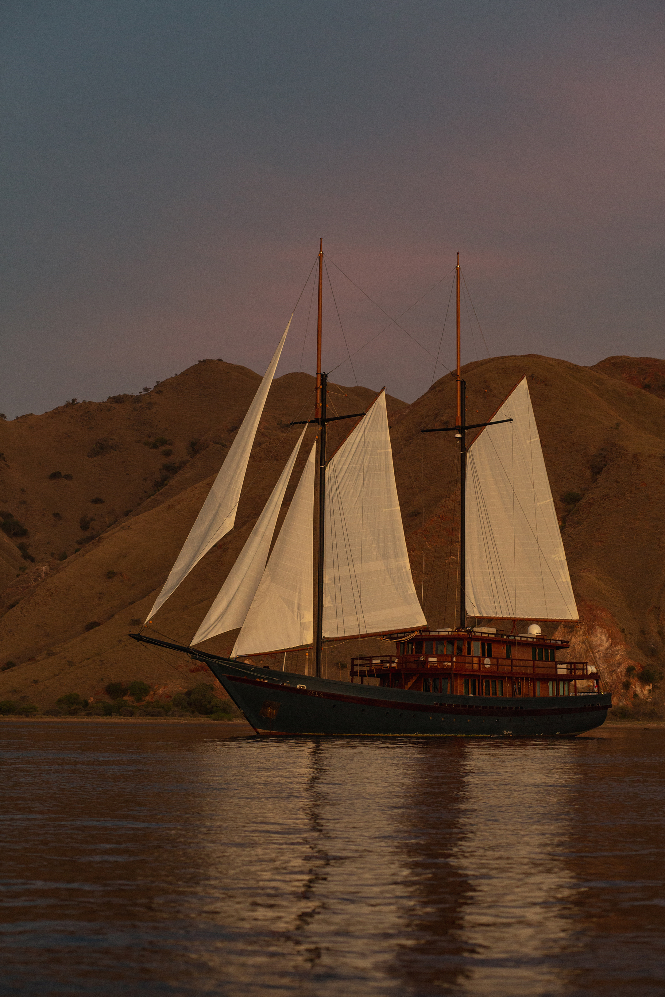 Portrait of Vela private yacht anchored before an island