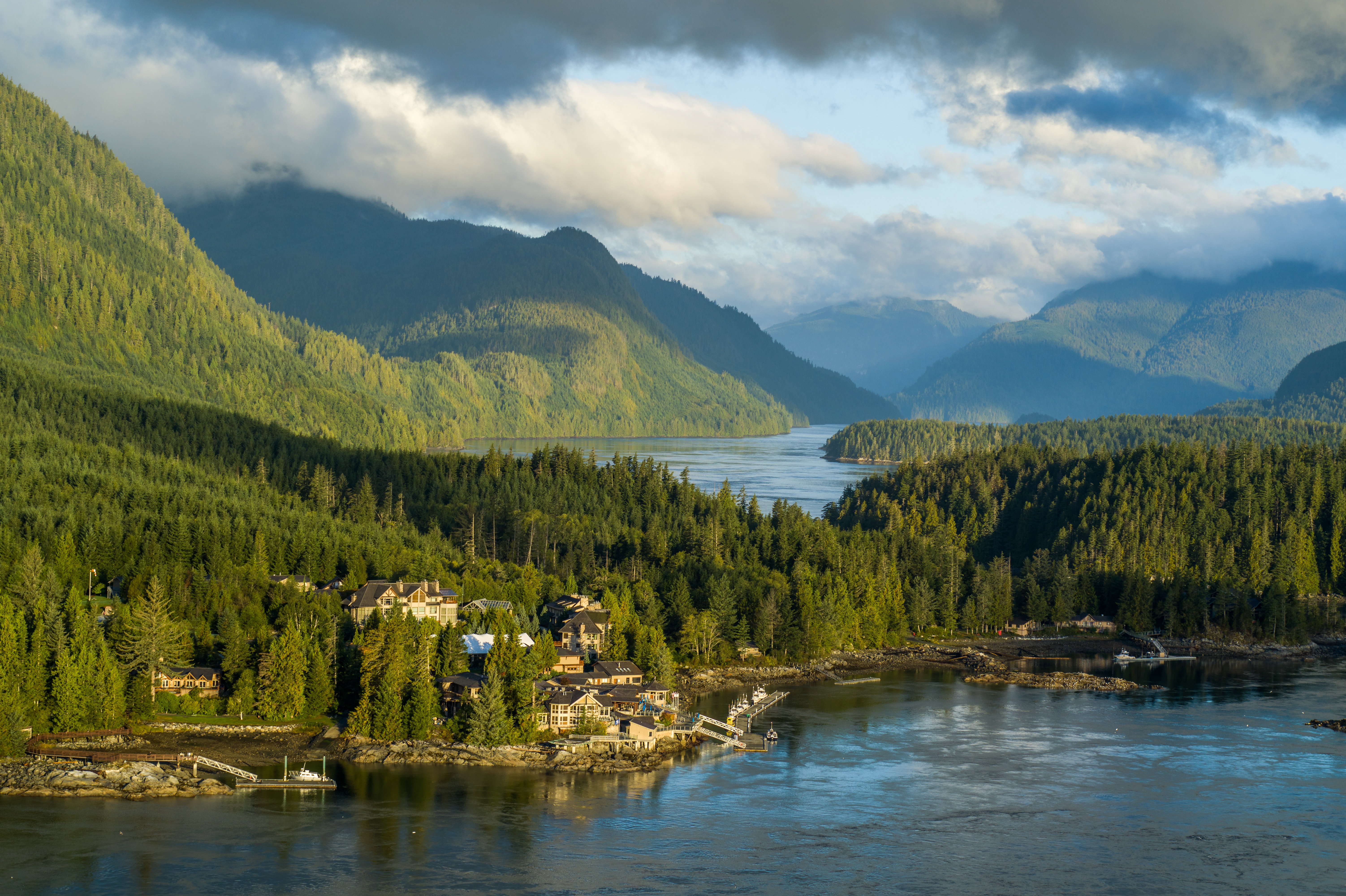 A vast landscape of tree covered mountains with the large lodge resort of Sonora by the side of a lake