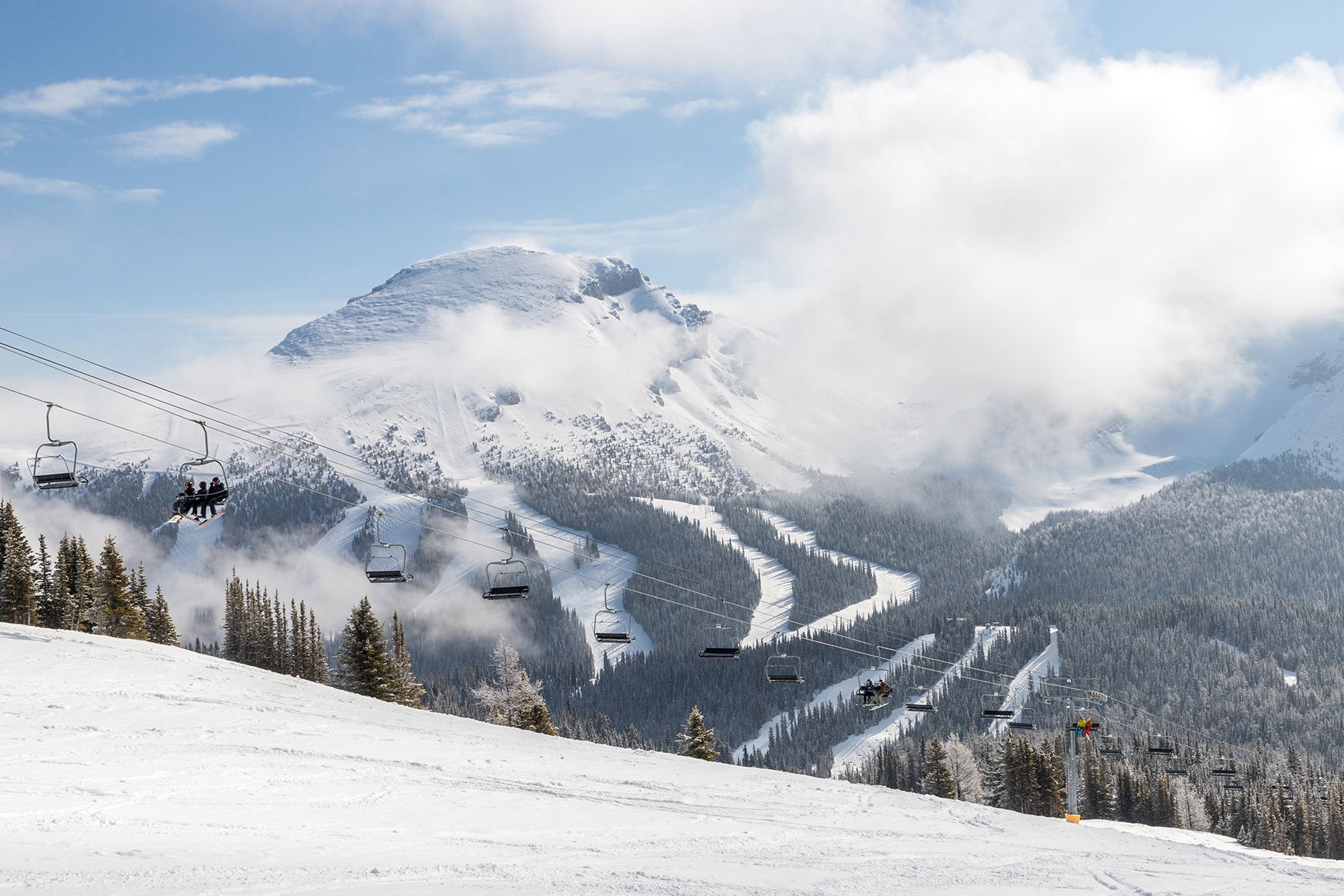 People on Canadian ski lift with mountains in background