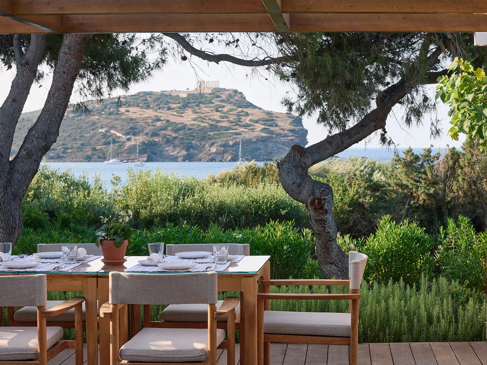 Europe, Greece, Athens Riviera, Cape Sounio, a table at the Aegean Grill restaurant with a view of the temple of poseidon 
