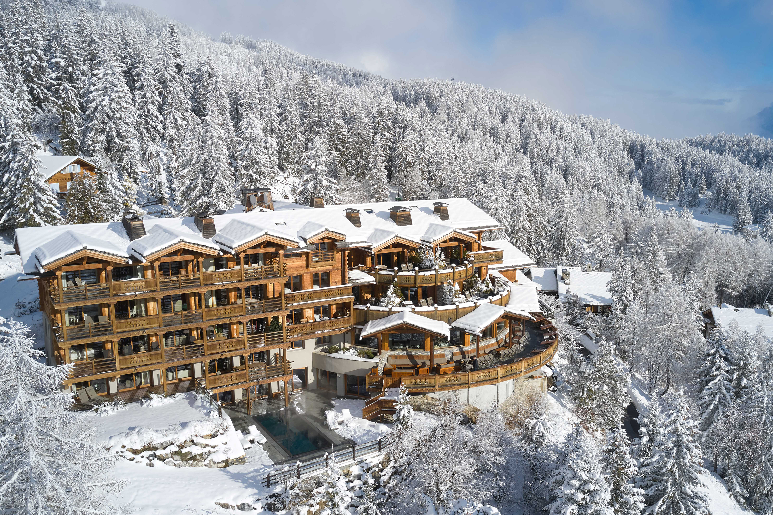 The wooden exterior of LeCrans Hotel & Spa on a clear and snowy day