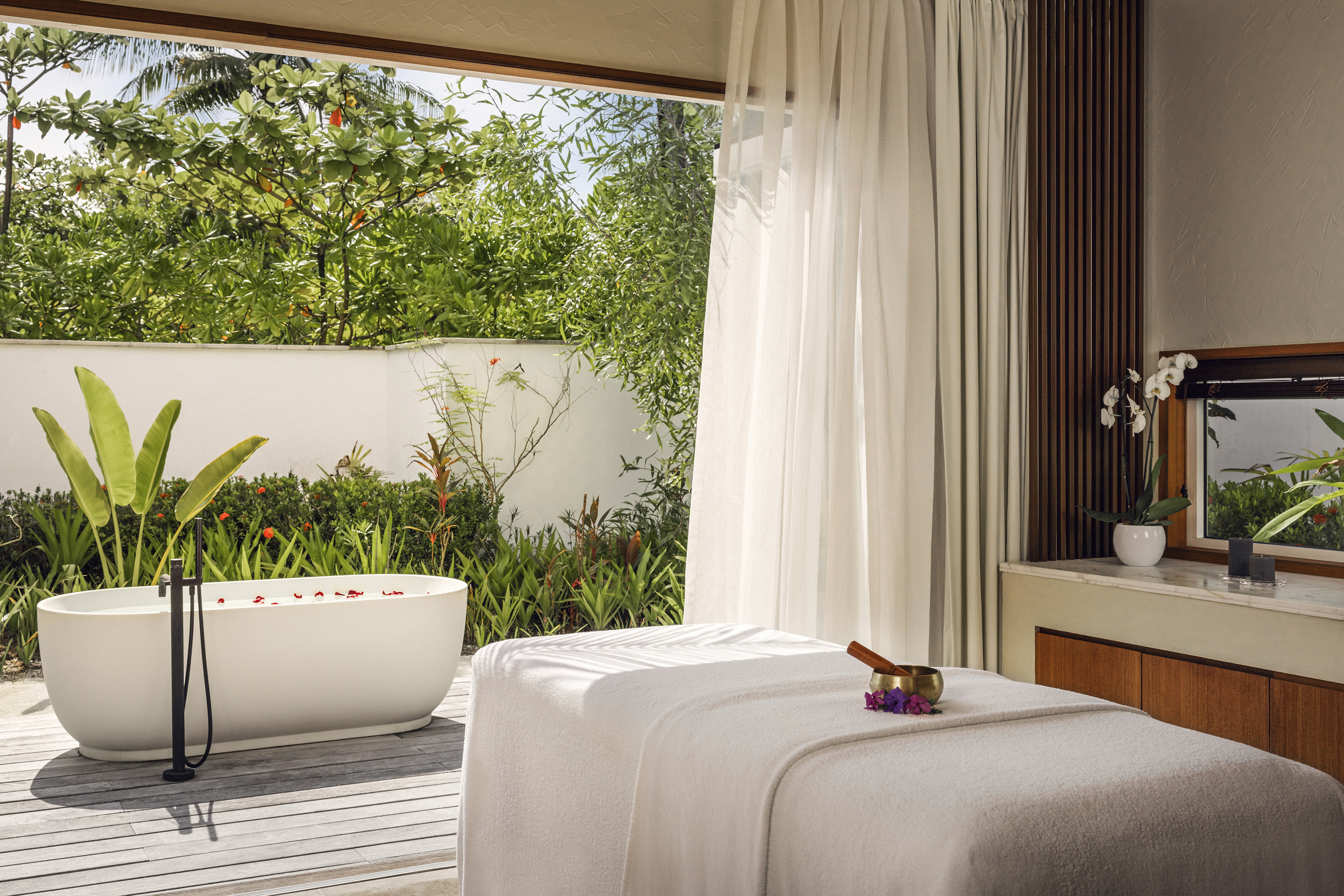 Single Garden Treatment Room of the spa with bathtub and pretty established greenery