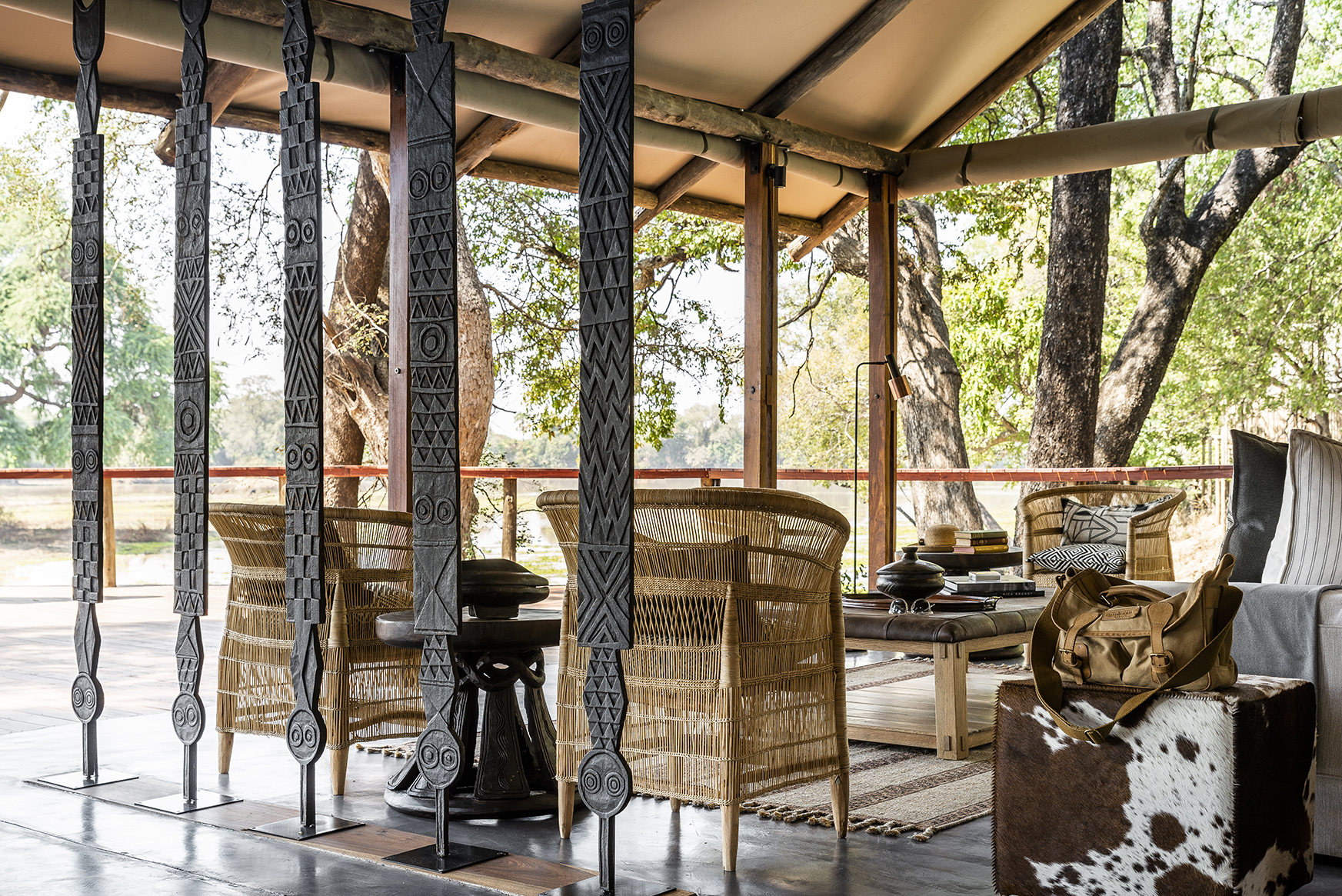 Africa, Zambia, Sungani Lodge, living space consisting of a sofa, coffee table and chair on a wooden veranda 