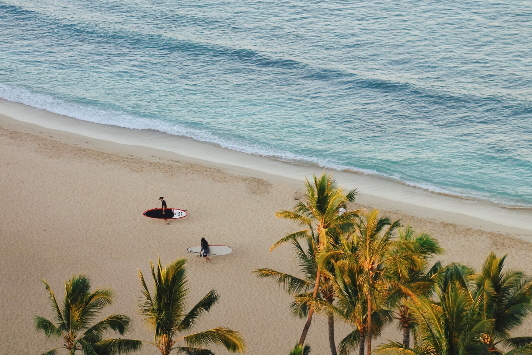 Two surfers on the beach in Hawaii