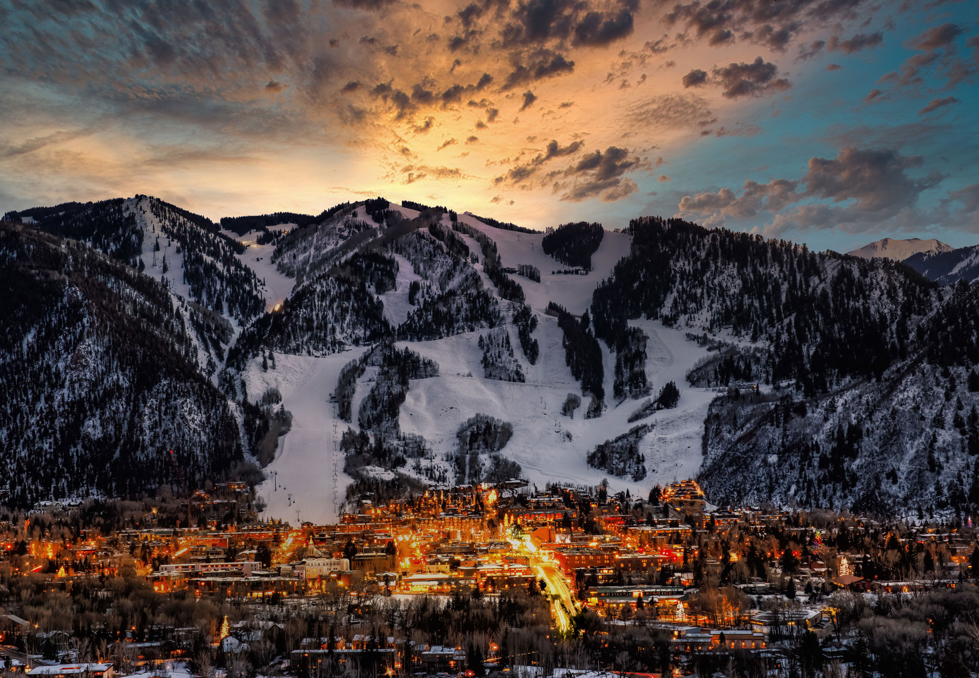 The skyline of the municipality of Aspen lit up during sunset
