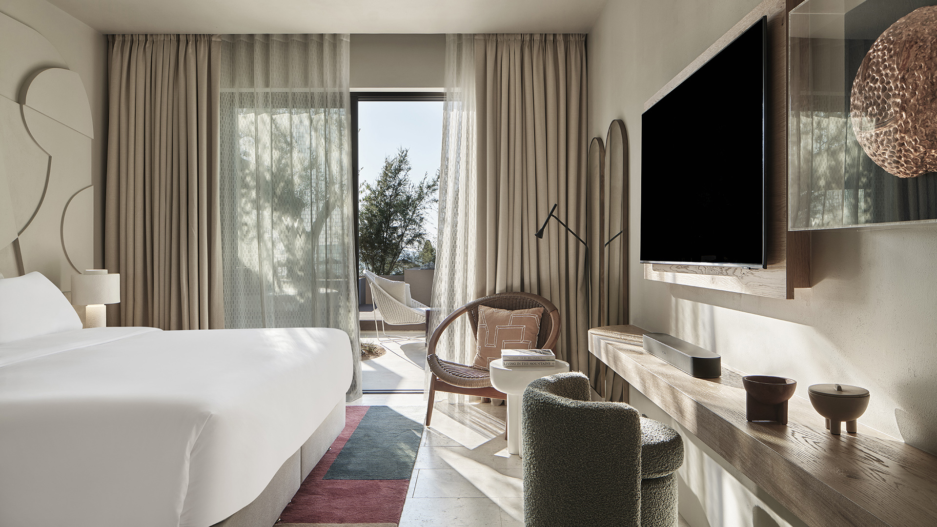 Villa bedroom with flat screen TV and door to terrace at W Costa Navarino