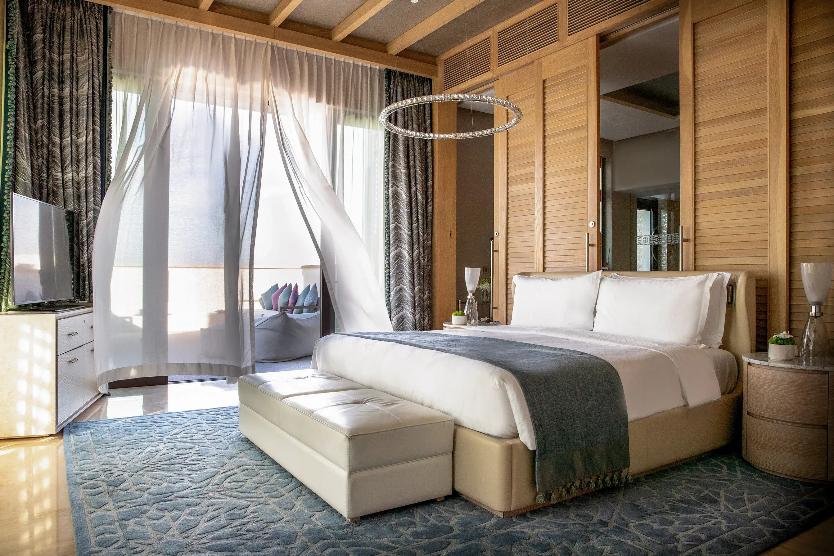 Luxury Presidential Suite bedroom at Jumeirah Al Naseem Dubai featuring elegant contemporary décor and a private terrace with flowing sheer curtains.