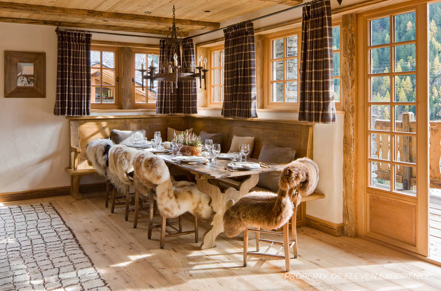 A long dining table and fur covered chairs 