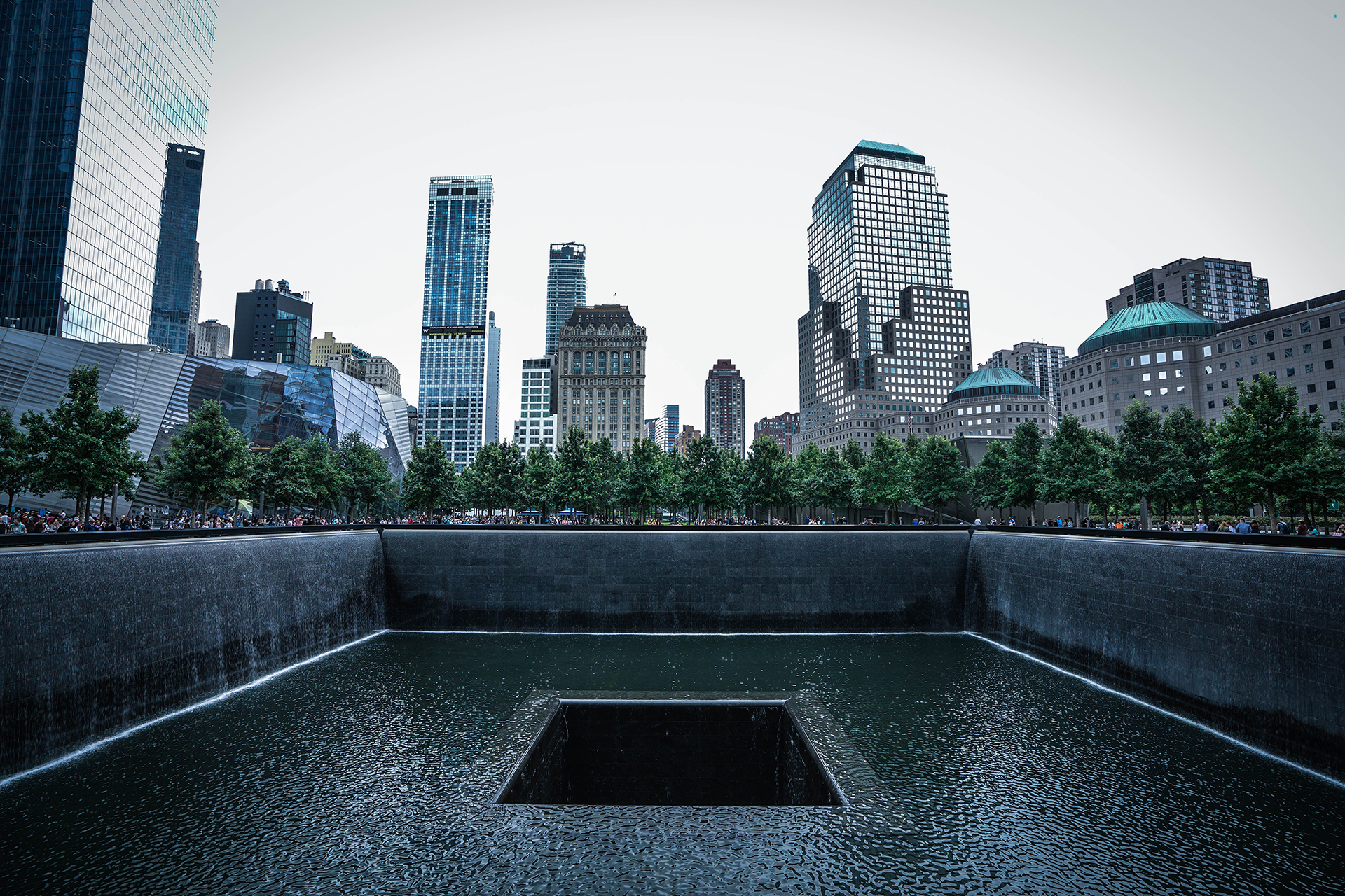 A view of the World Trade Center memorial with high rise buildings in the background