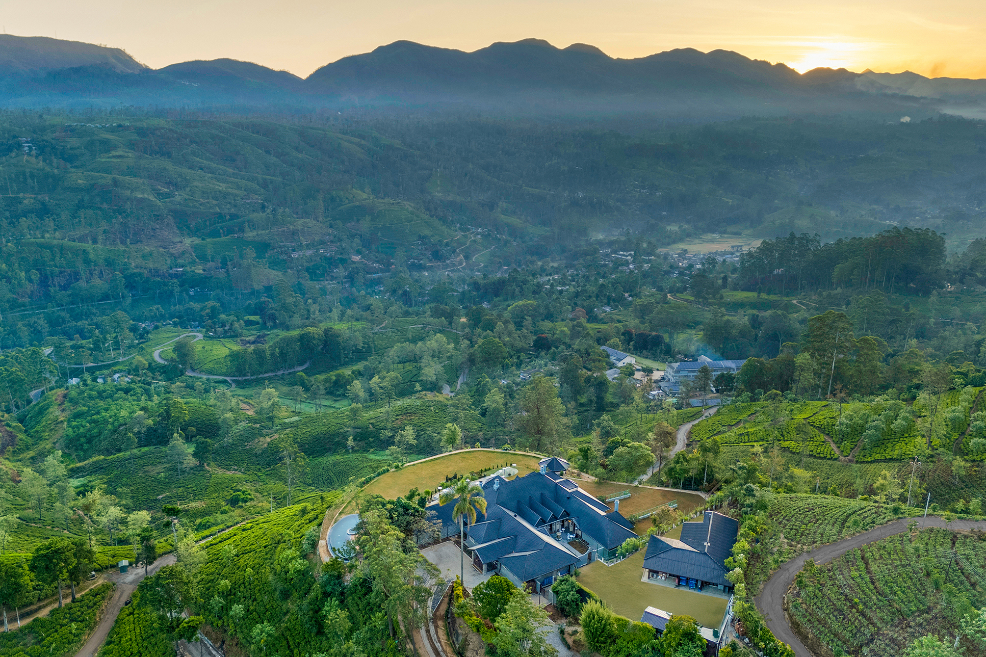 The landscape of Sri Lanka's Tea Country around Uga Halloowella with rolling hills and the top of the hotel