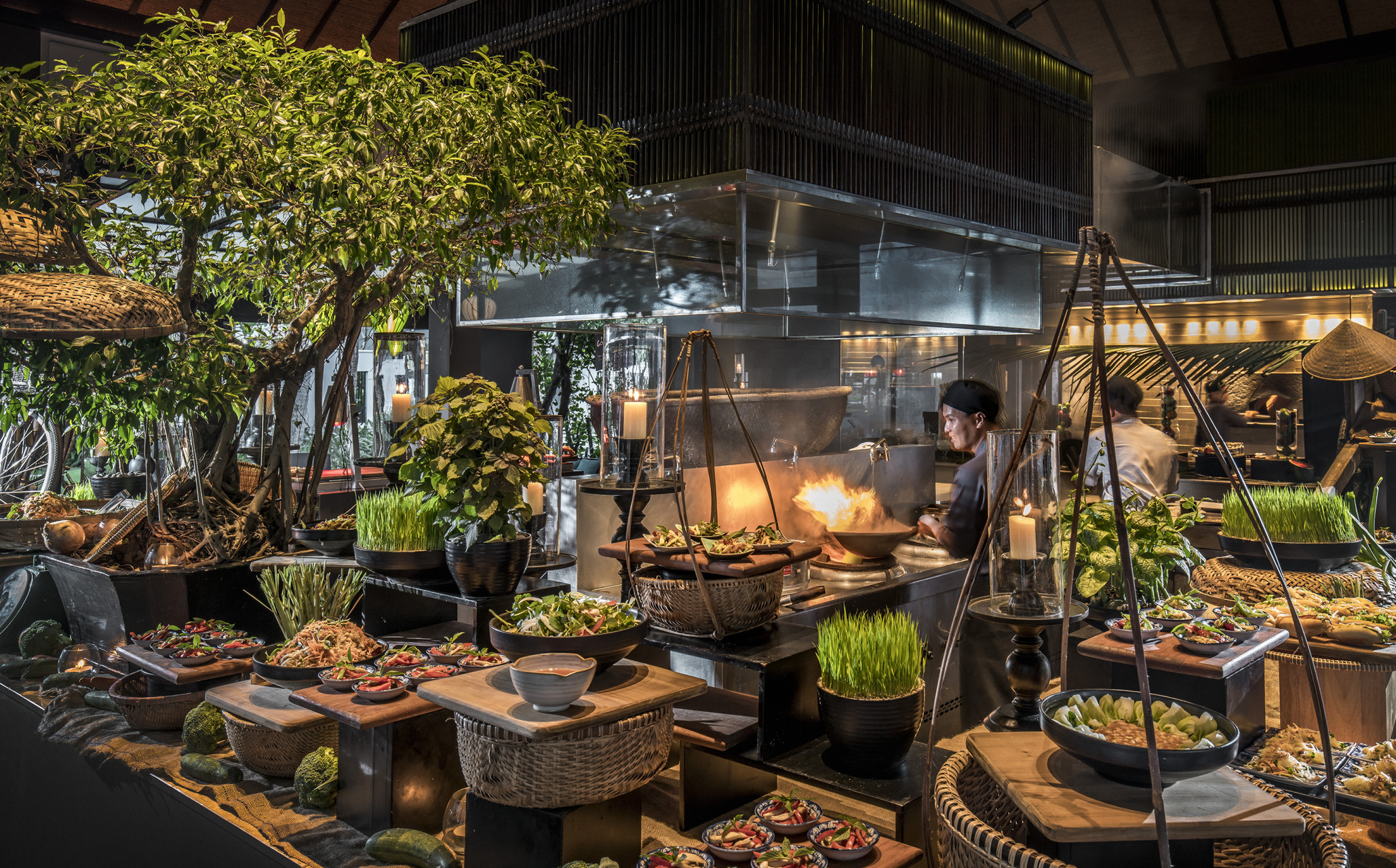 A open kitchen with food laid out buffet style and a chef cooking at Four Seasons Resort Nam Hai