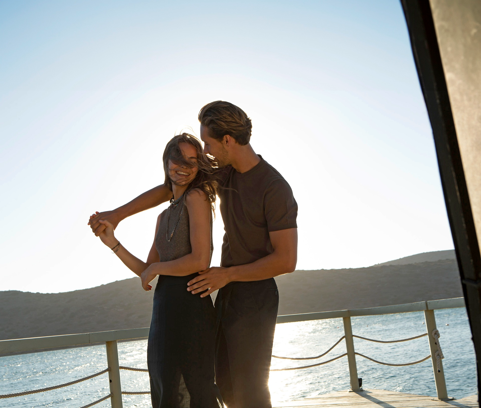 Couple enjoying a sunset stroll beside the sea at a luxury Mediterranean resort