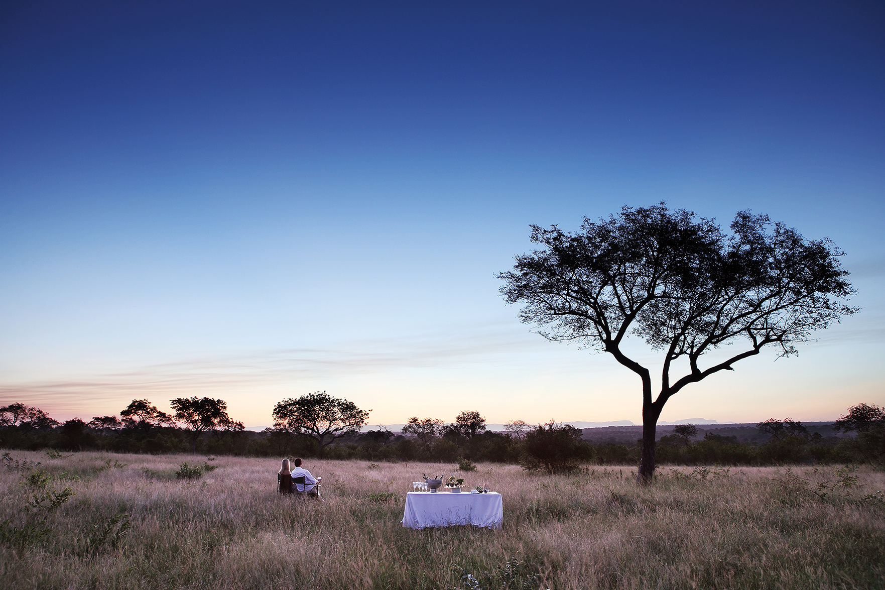 Couple drinking sundowners in Londolozi Game Reserve