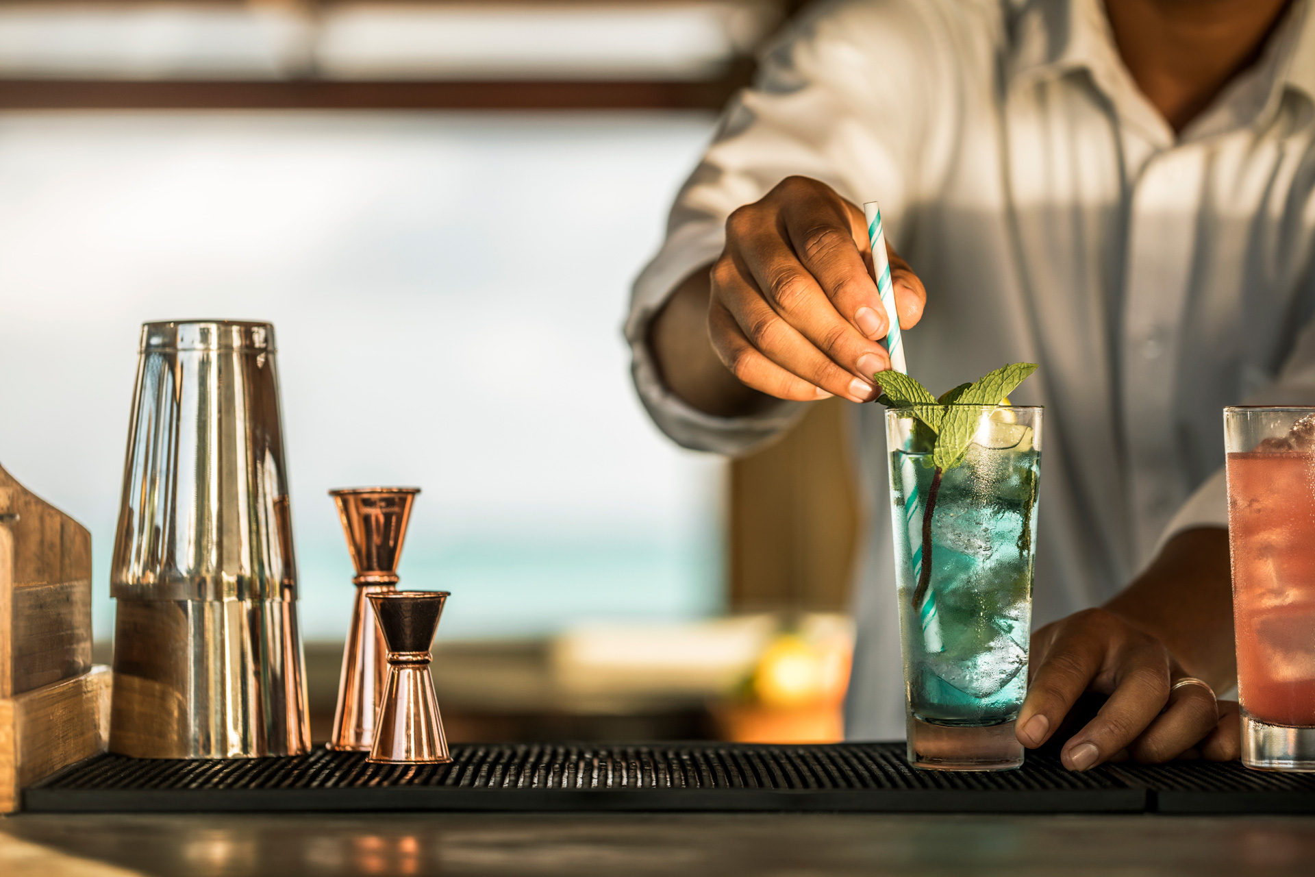 A bar staff preparing a cocktail on a bar top