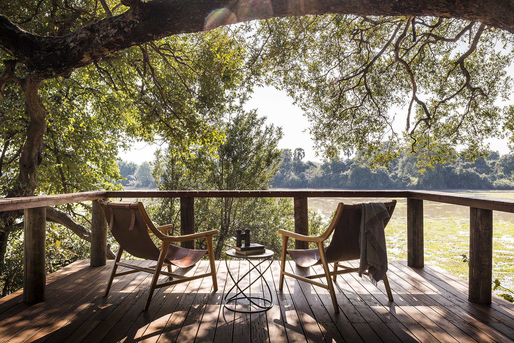 Africa, Zambia, Sungani Lodge, chairs and a table with books and binoculars on a wooden viwing platform