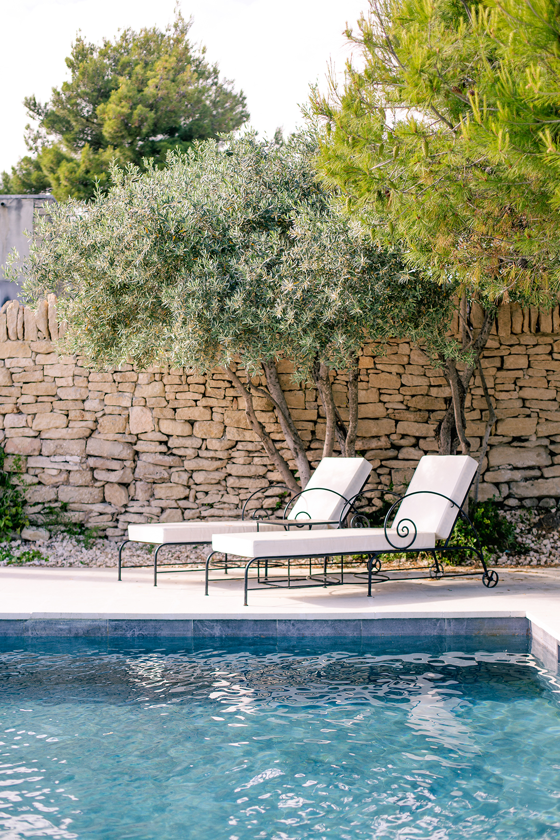 Two sun loungers beside a pool 