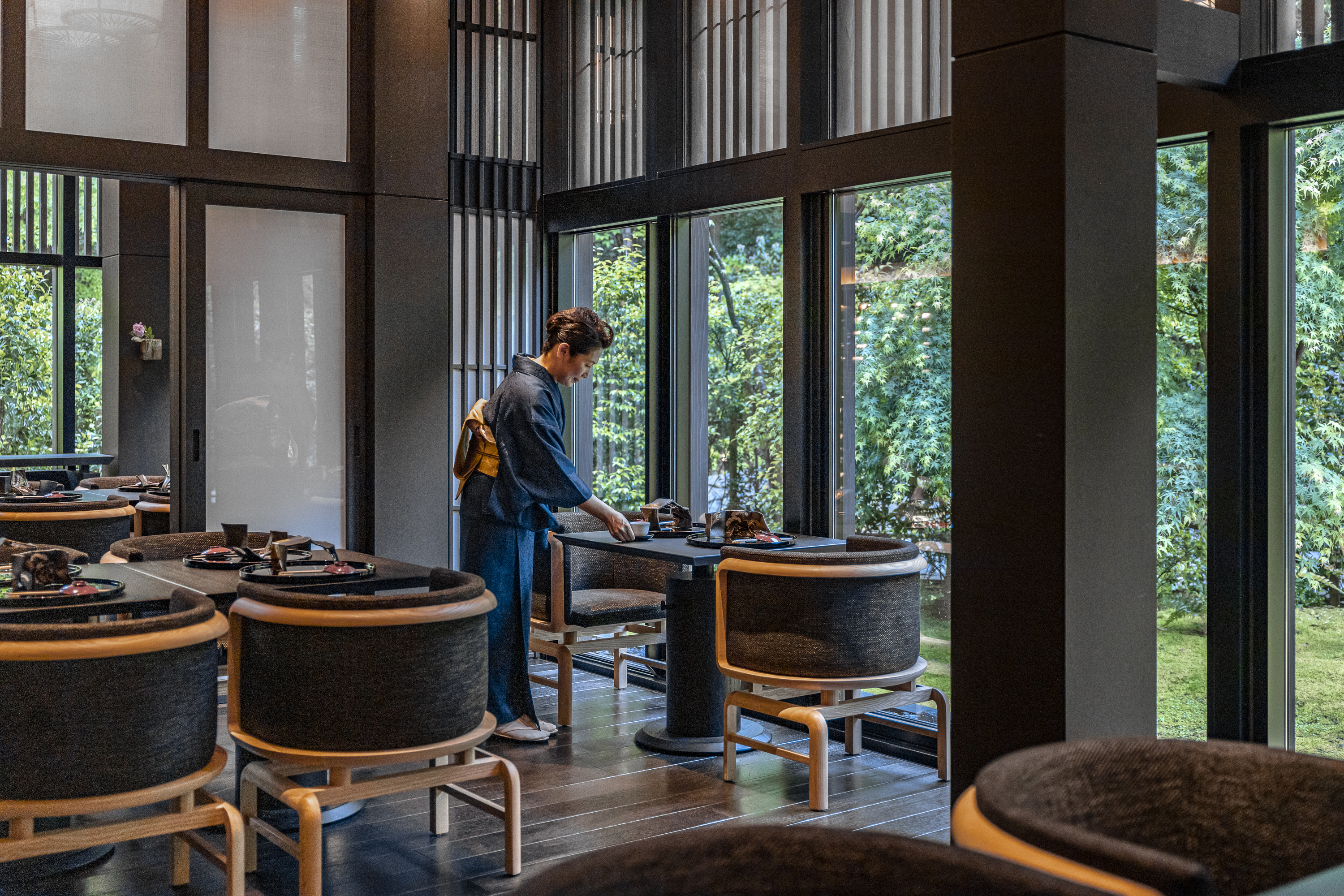 A waitress setting a table in Taka An Restaurant by the window 