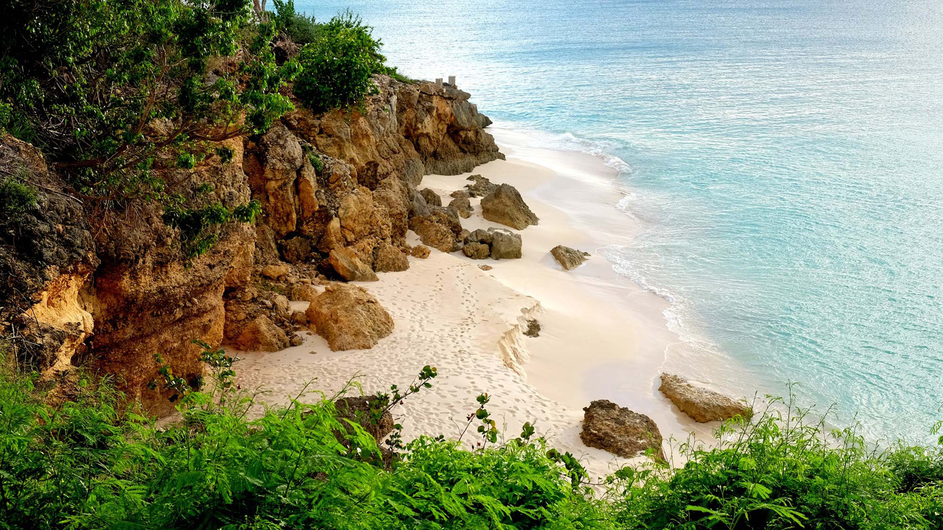 Looking from a cliff top at a small beach outcropping
