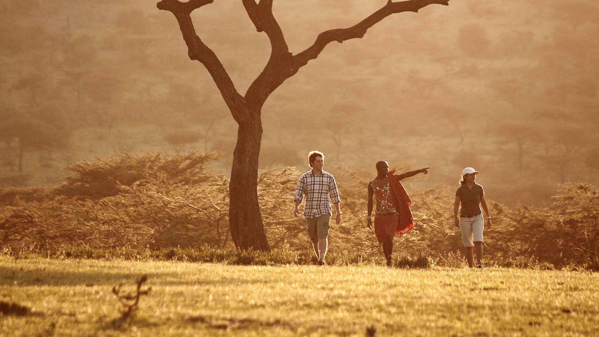 A local guide with tourists at Mara Bushtops pointing