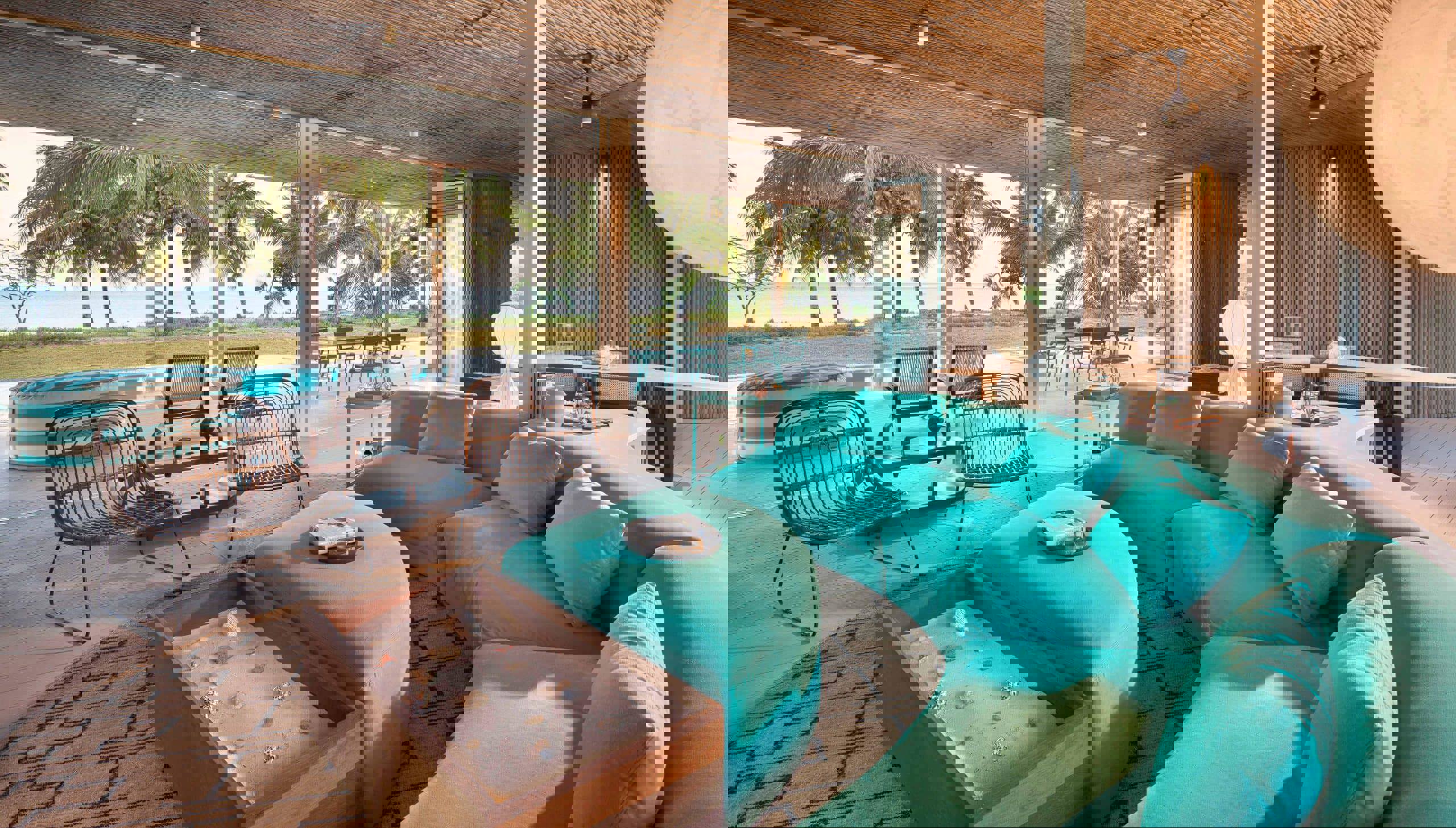 Curved blue sofa and chairs in the lounge of a villa at Miavana