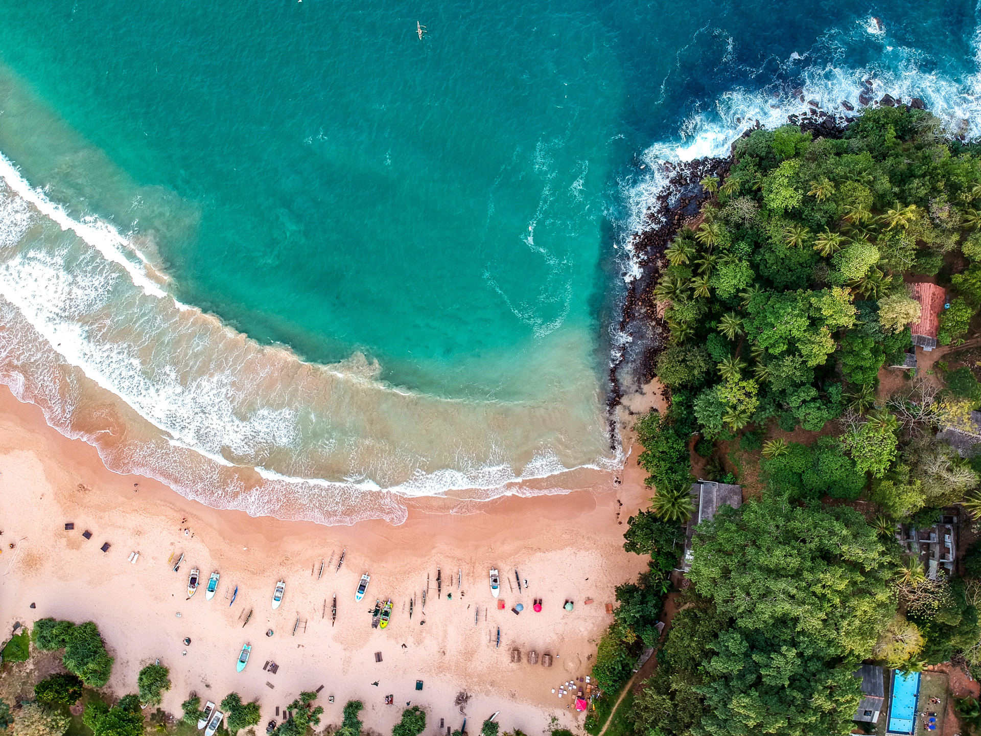 A birds eye view of a beach with trees to the right