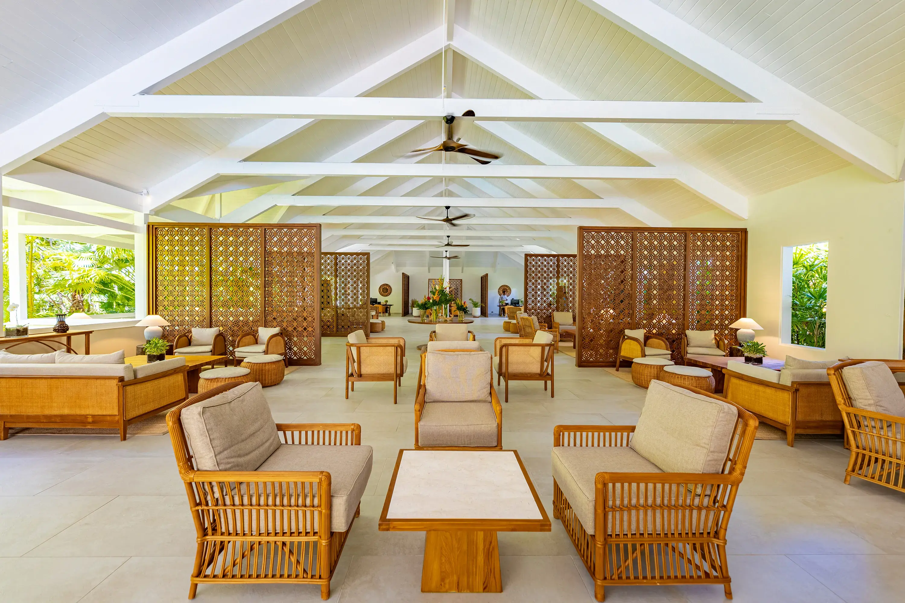 The light and airy lobby of Carlisle Bay featuring comfy rattan furniture beneath vaulted ceilings