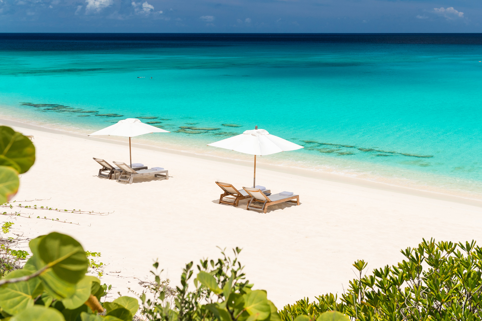 Two sun loungers with umbrellas on a sandy beach
