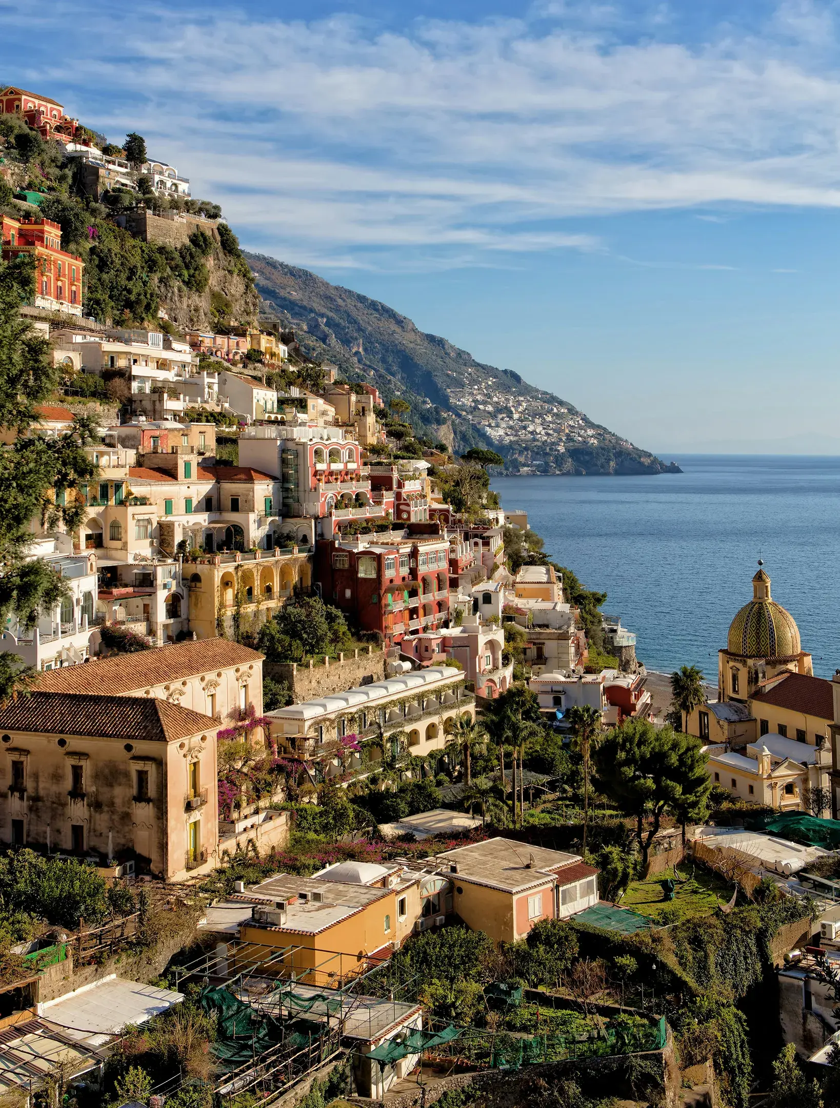 Colorful cliffside houses overlooking the blue sea in Positano on Italy’s Amalfi Coast under a clear sky.