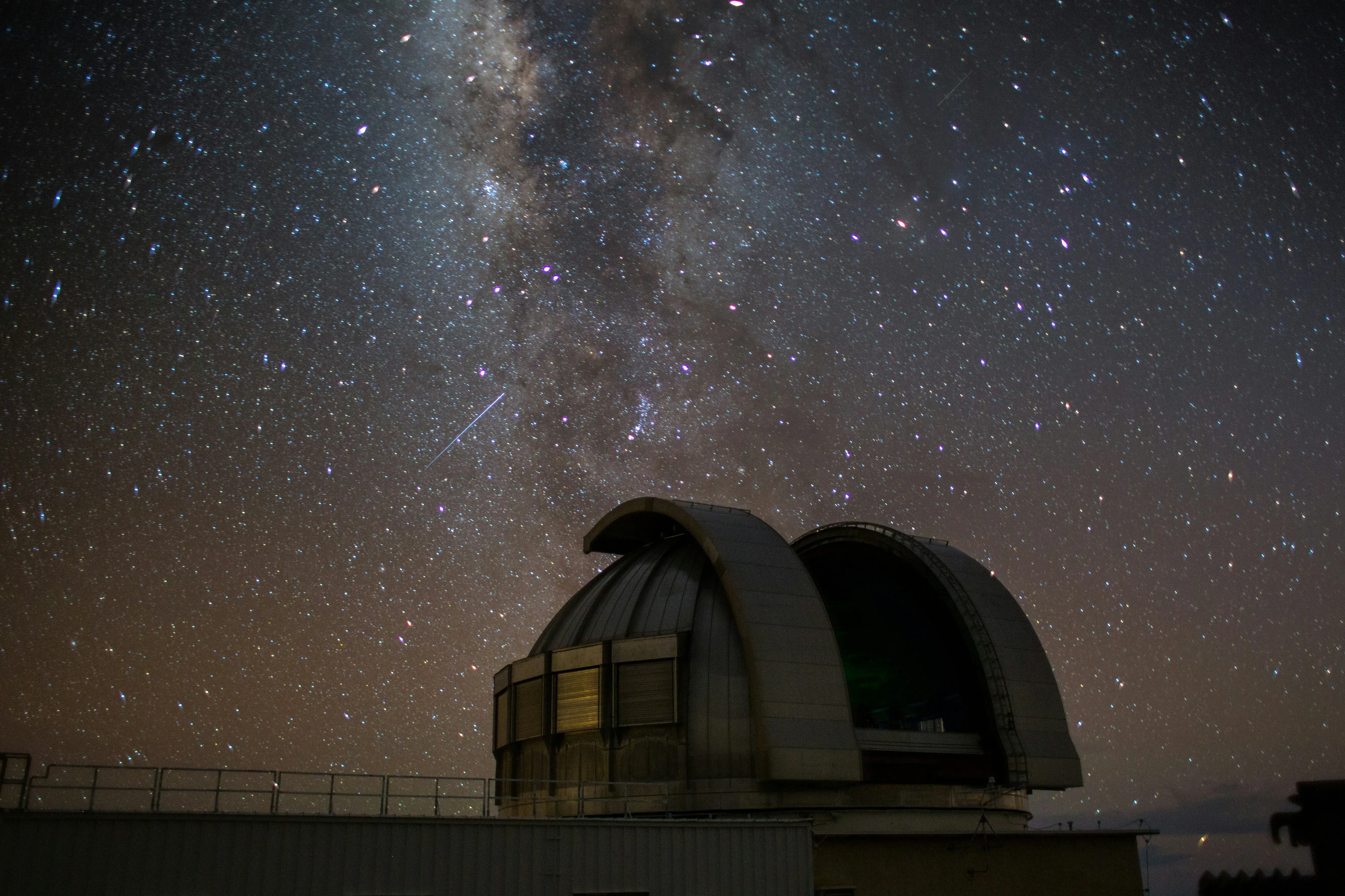 The dome of Mauna Kea observatory below the milky way at night