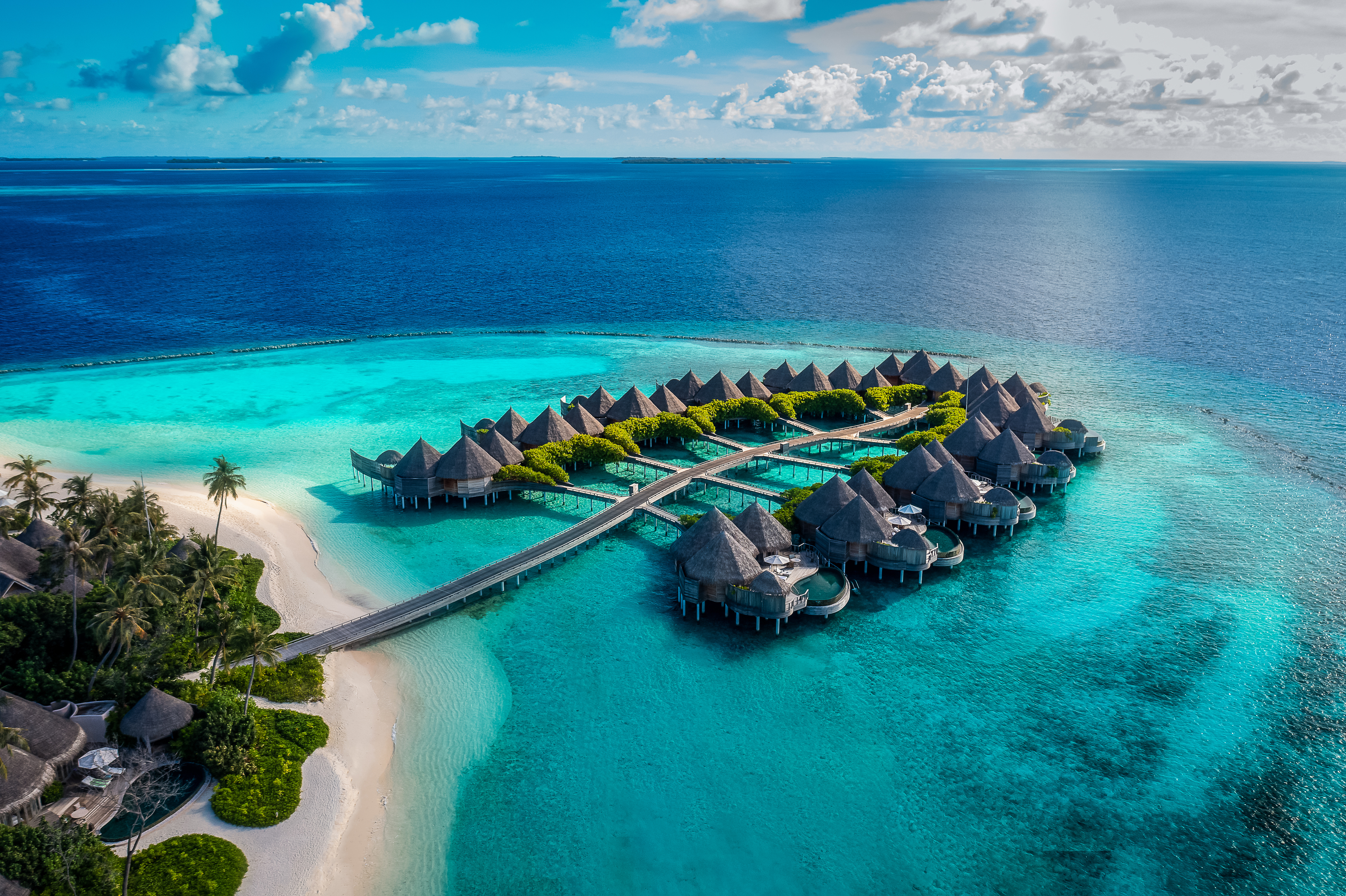 A group of thatched roofed overwater villas at The Nautilus, Maldives