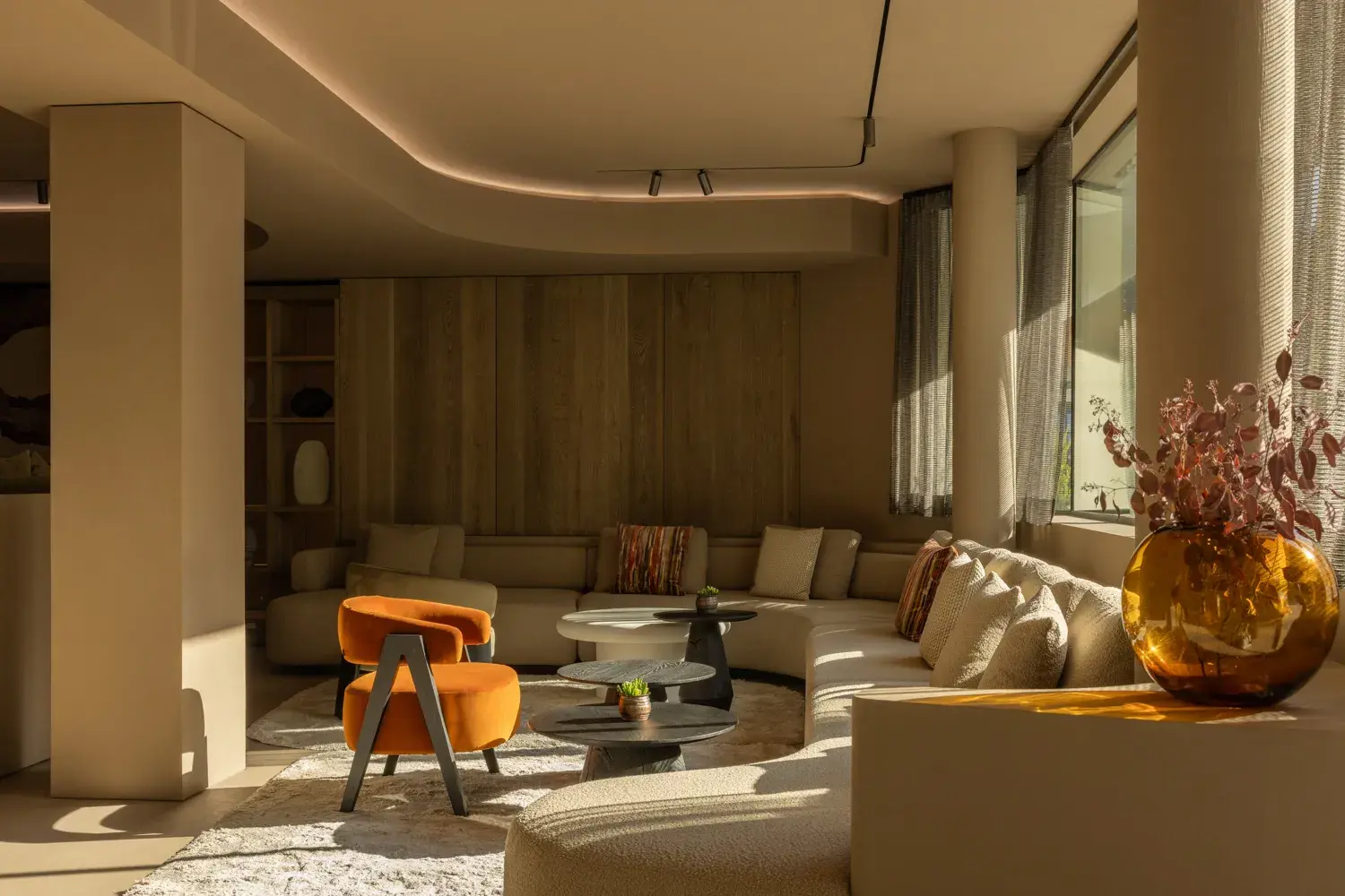 A modern lounge area at the Gourmet and Wine Hotel Austria, with wooden walls, statement chairs and warm-toned decor 