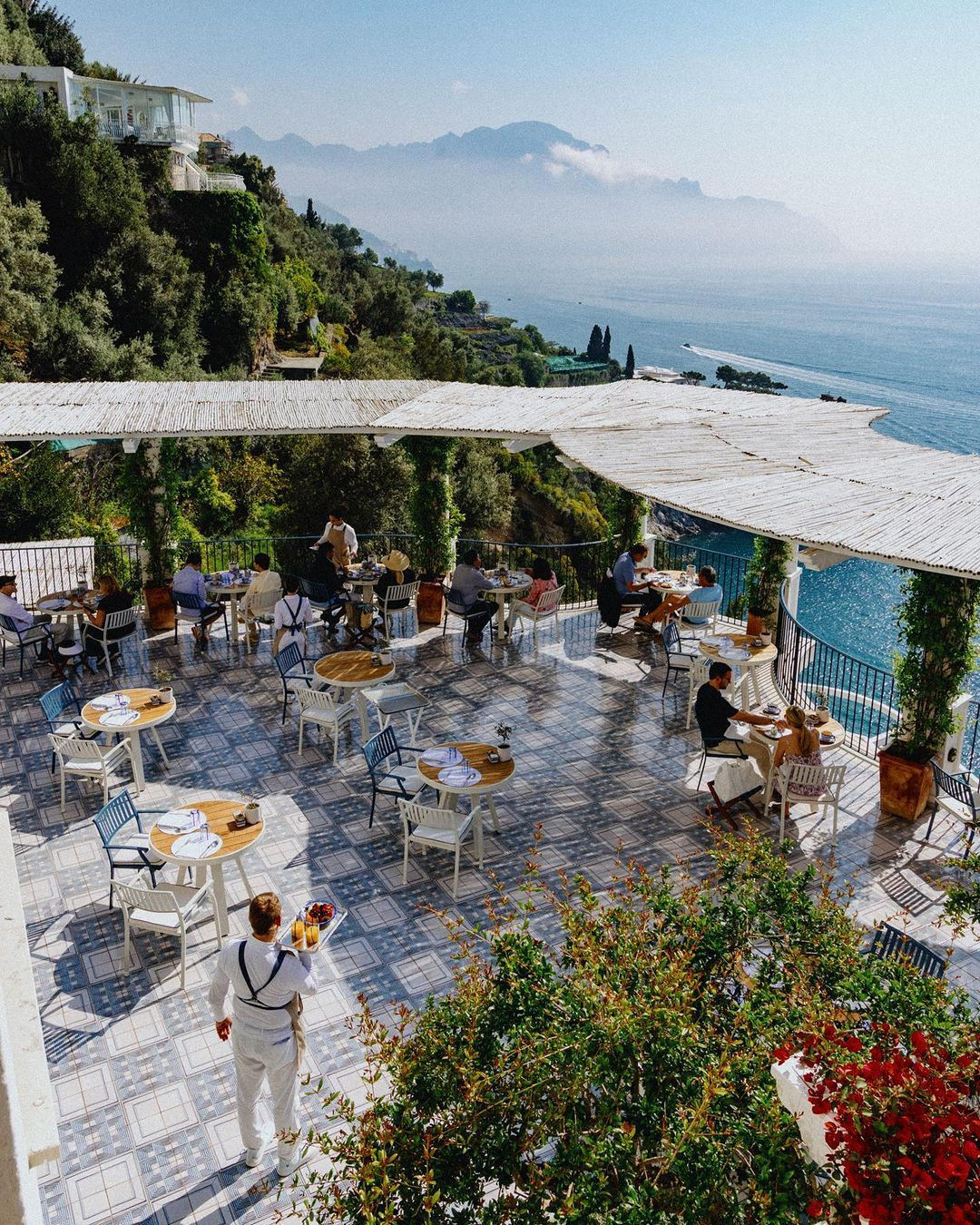 Scenic outdoor breakfast setting at Borgo Santandrea in Amalfi with lush greenery and breathtaking coastal views.