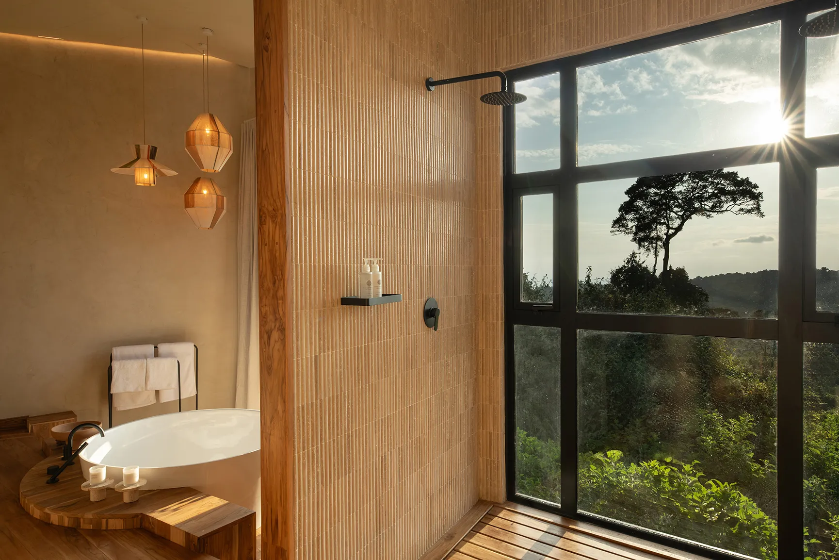 Freestanding bathtub and walk-in shower with panoramic forest views
