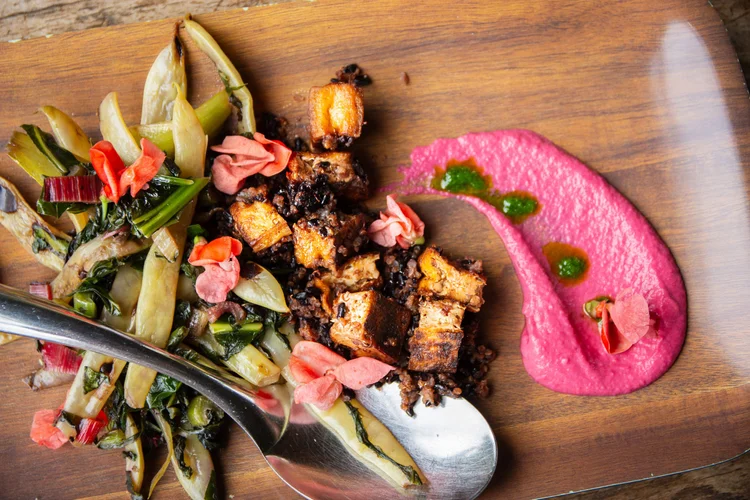 A platter of chargrilled vegetables with pink beetroot sauce and a silver spoon