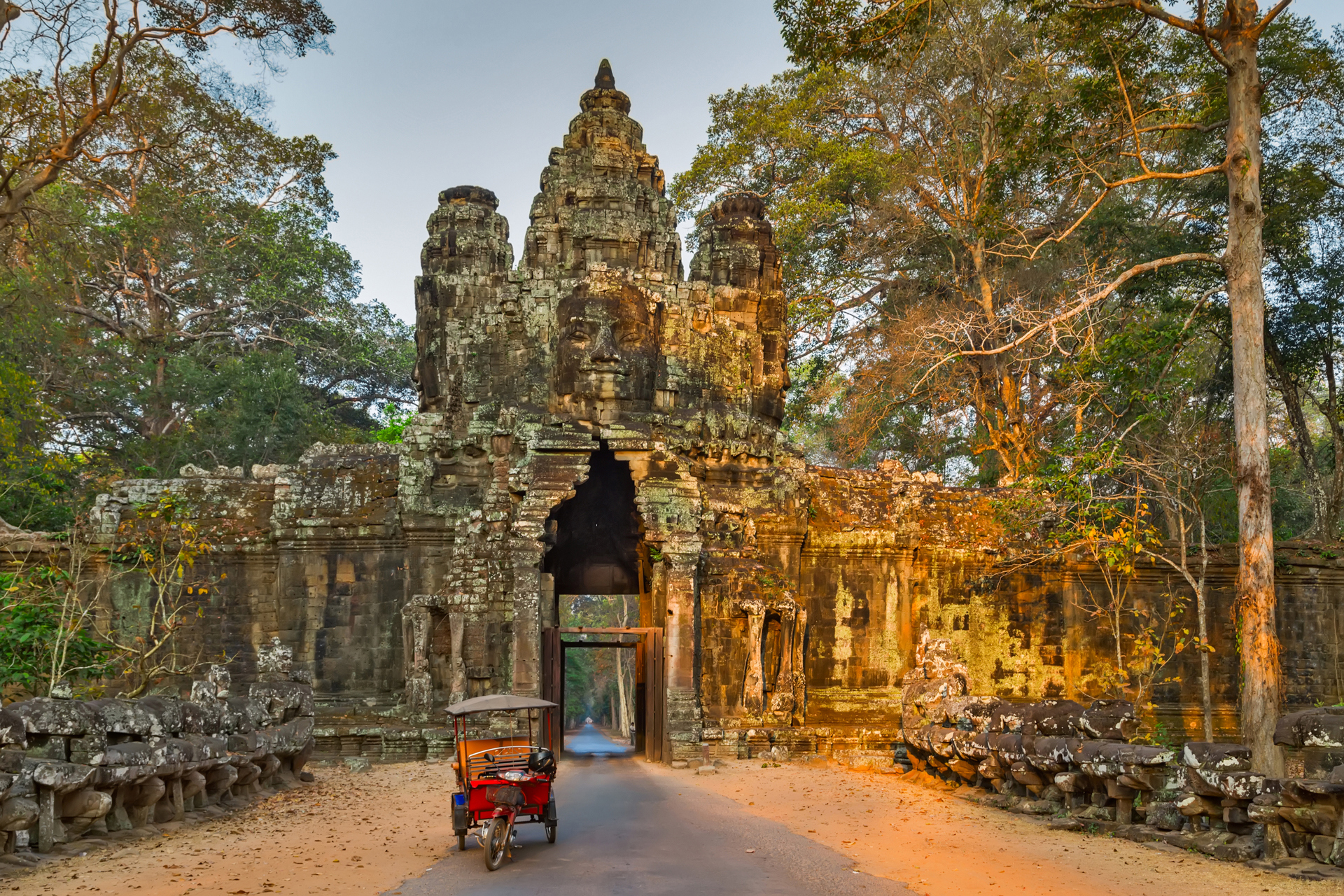 a stone arch structure with a red tuktuk in front of it