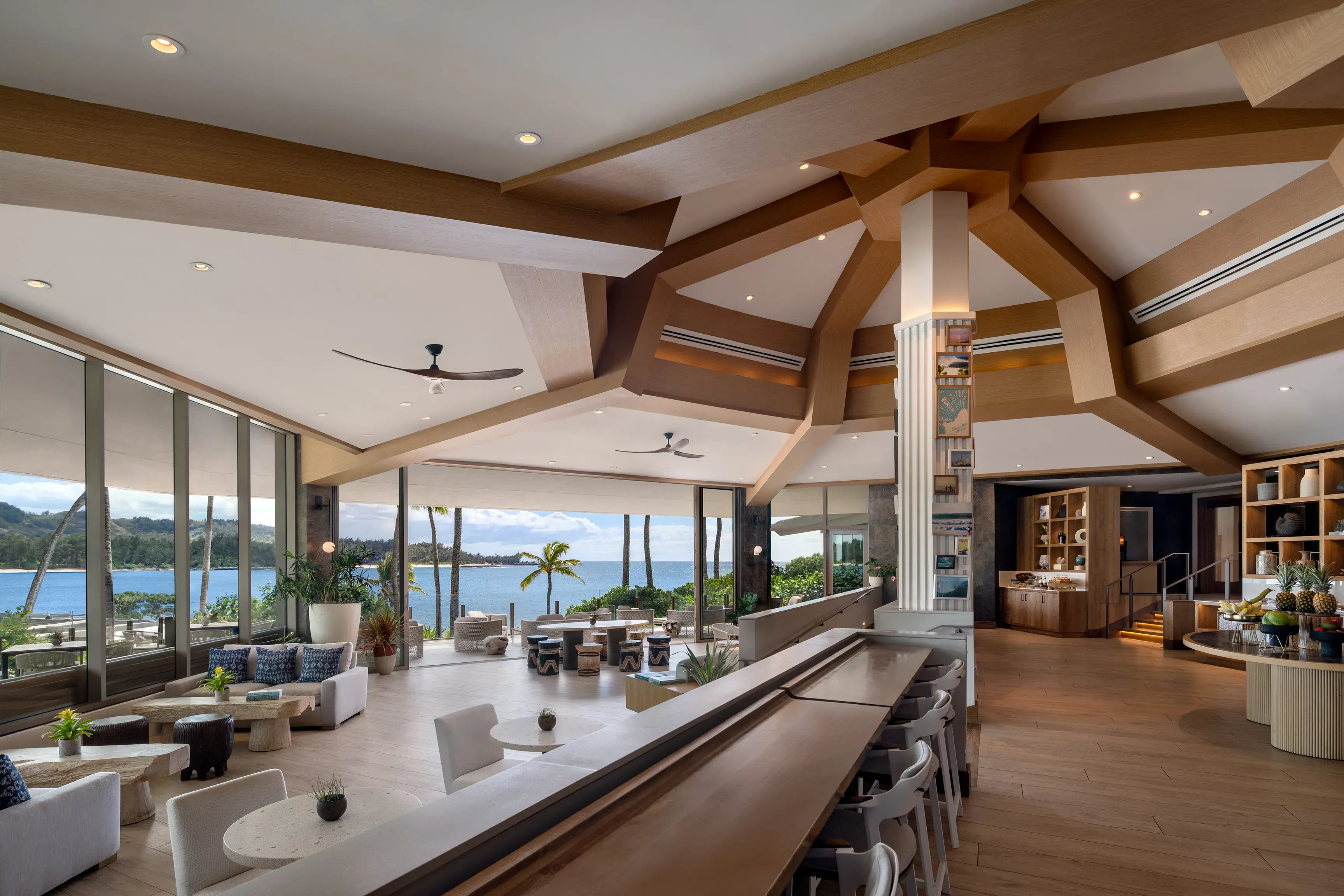 Interior of the Ritz-Carlton Club at Ritz-Carlton Turtle Bay featuring a high vaulted ceiling, spacious lounge area, decorated shelving and large floor-to-ceiling windows