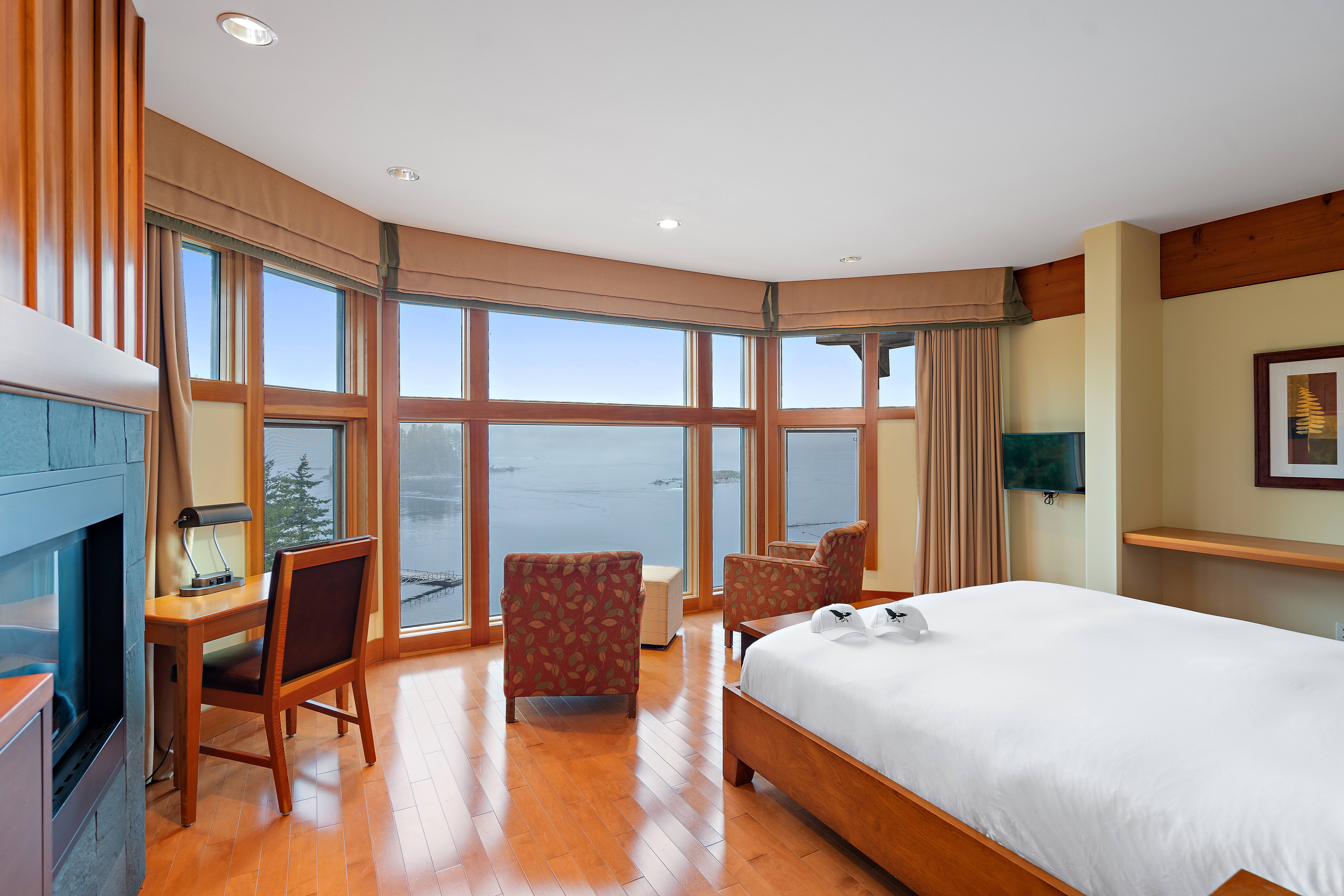 A Diamond Ocean Room at Sonora Resort featuring a bed with white linens and patterned chairs facing the view
