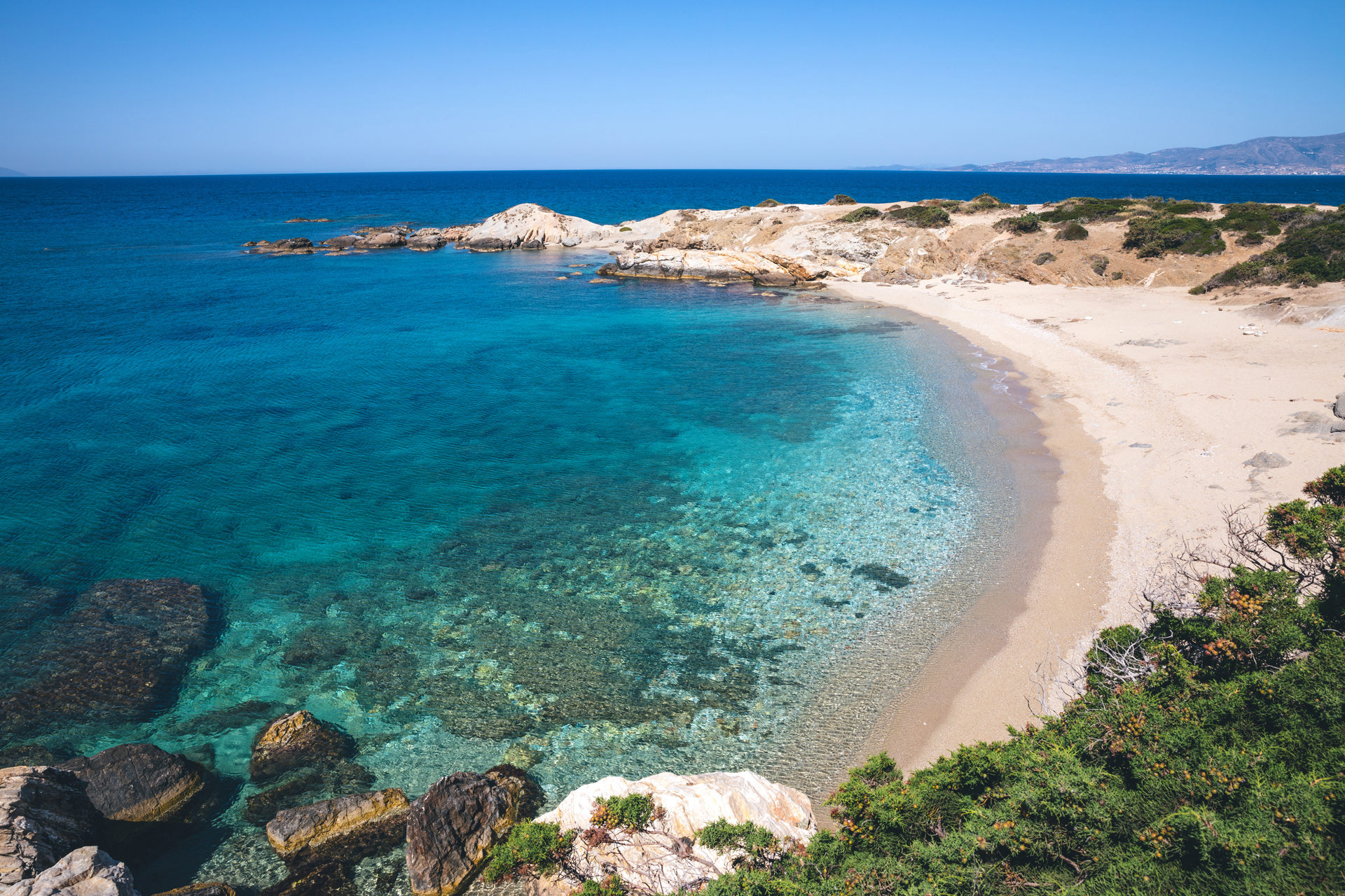 A remote sandy beach with clear sea water in Naxos, Greece