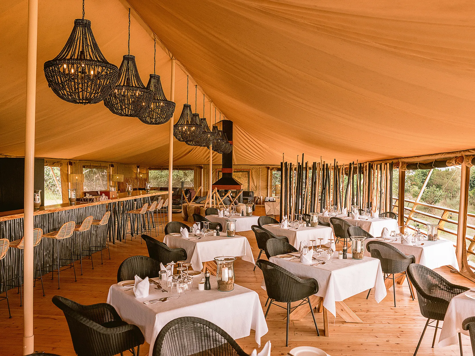 Africa, Tanzania, Serengeti Bushtops, dining tables and bar set for dinner in mess tent 