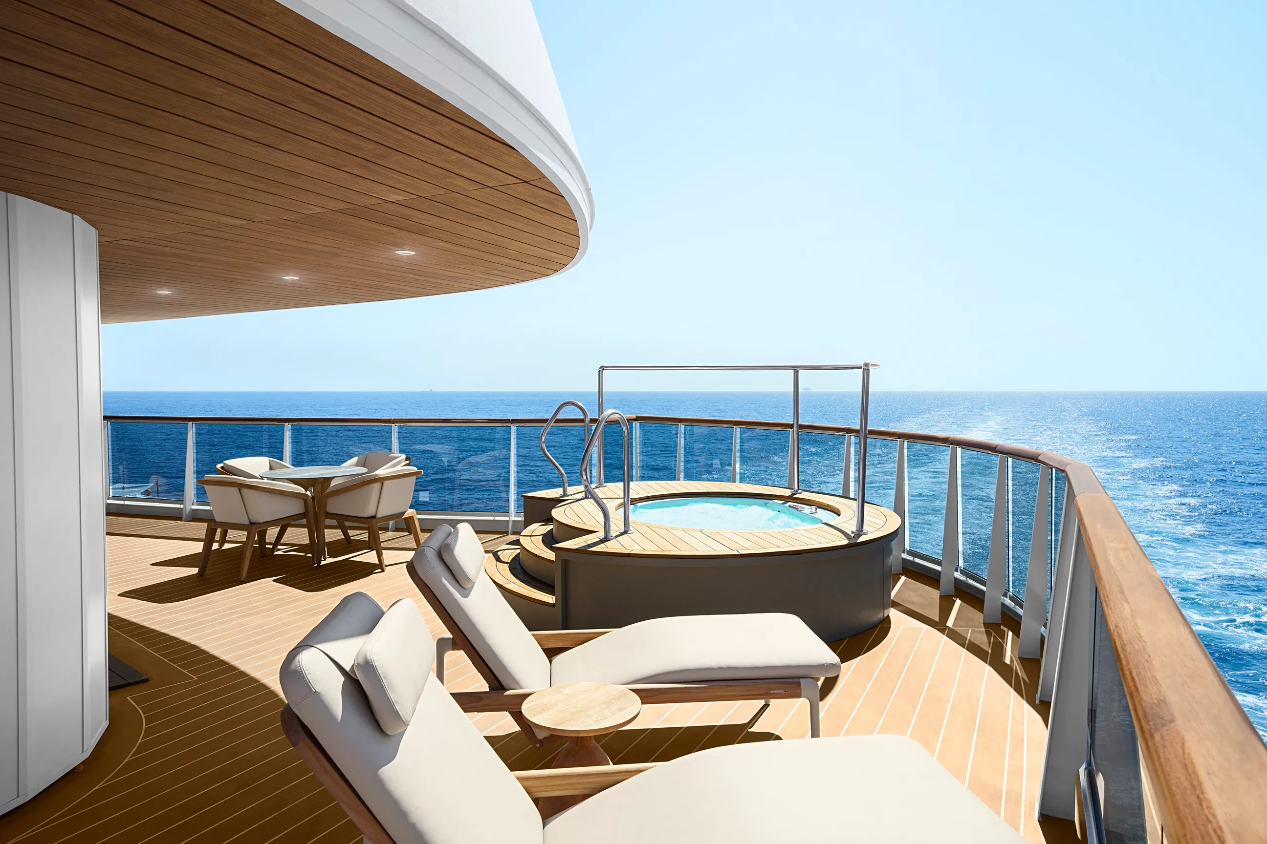 Luxurious yacht deck with sun loungers, a round pool, and a dining area overlooking the open sea.