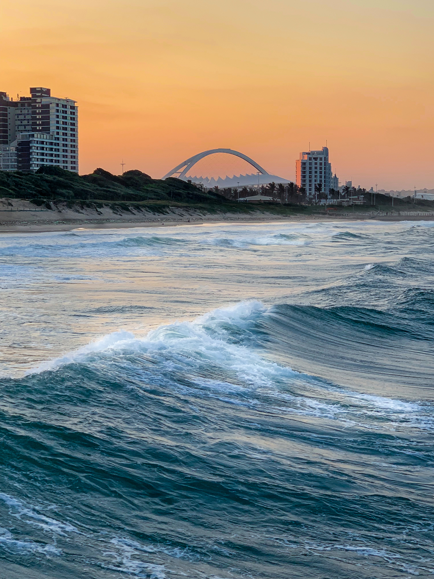 a view of the city coast from the sea during sunset