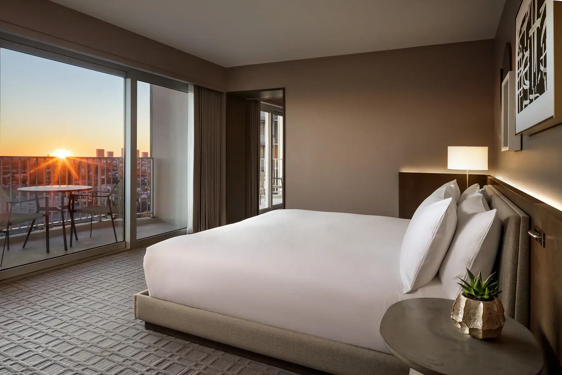Luxury California Suite guest room at Fairmont Century Plaza in Los Angeles featuring a plush king bed and a private balcony with sunset city views.