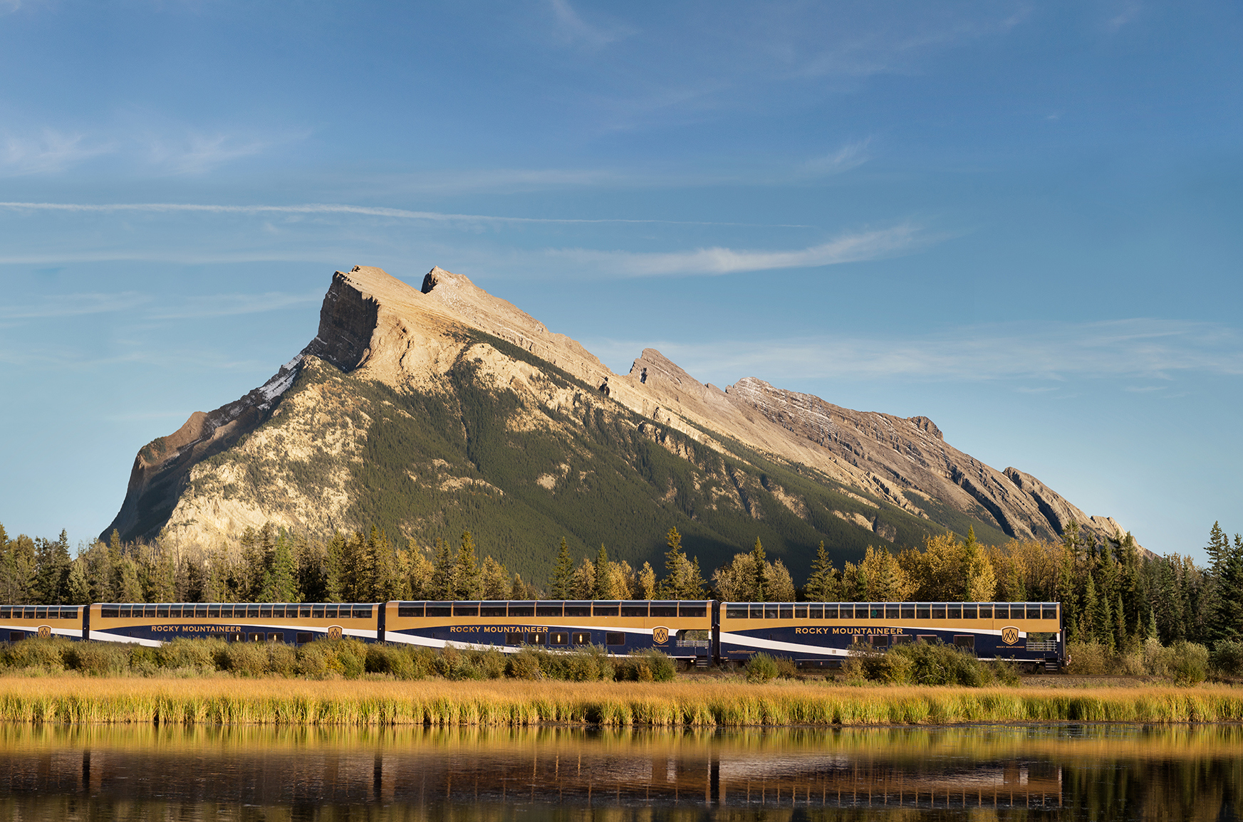 Canadian Rocky Mountaineer train passing a mountain in background