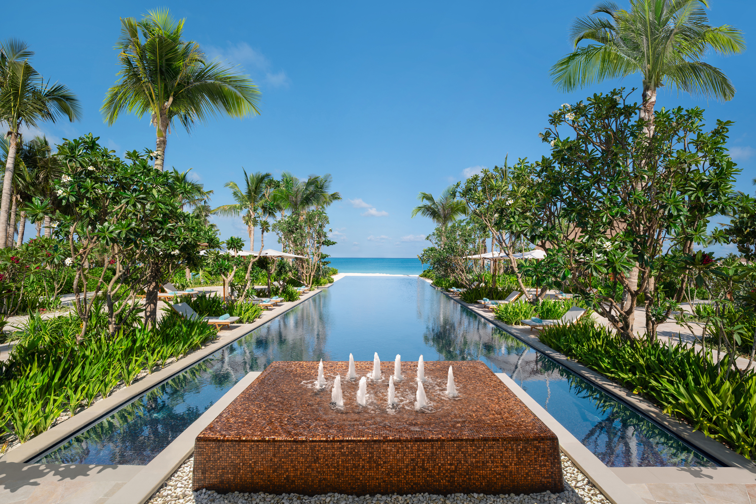 Water feature at the top of the mirror pool flanked by palms