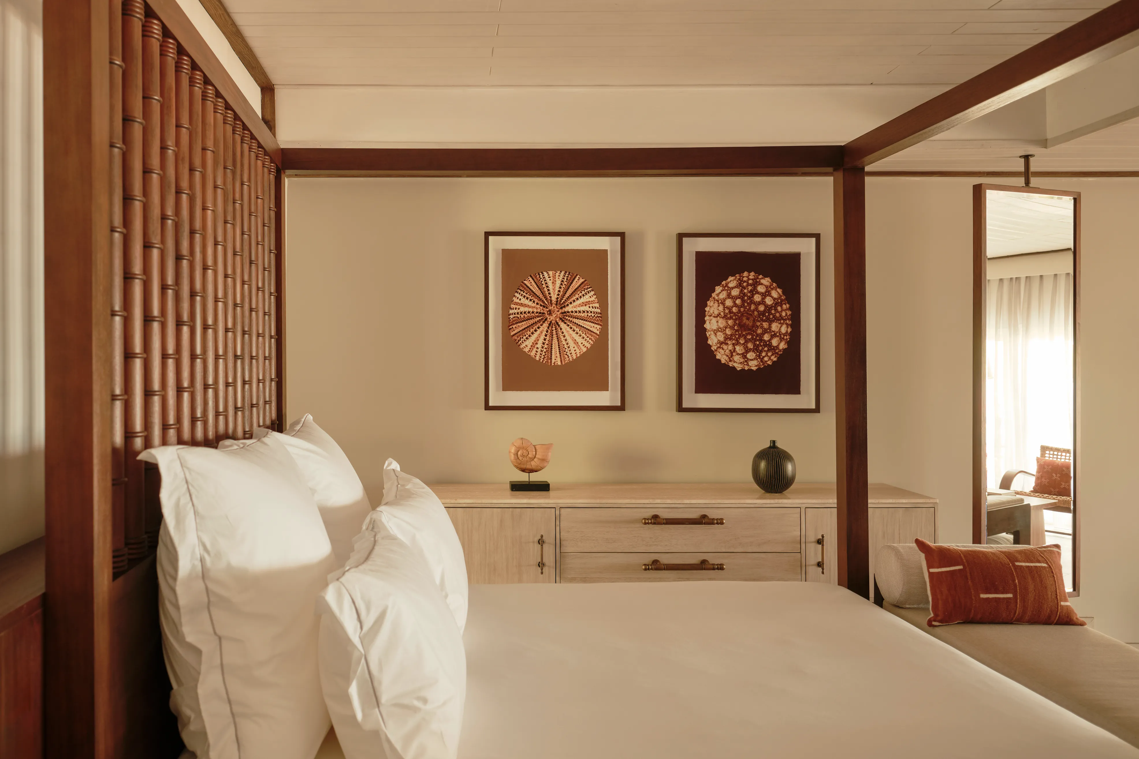 Ocean suite bed with warm neutral soft furnishings at Carlisle Bay