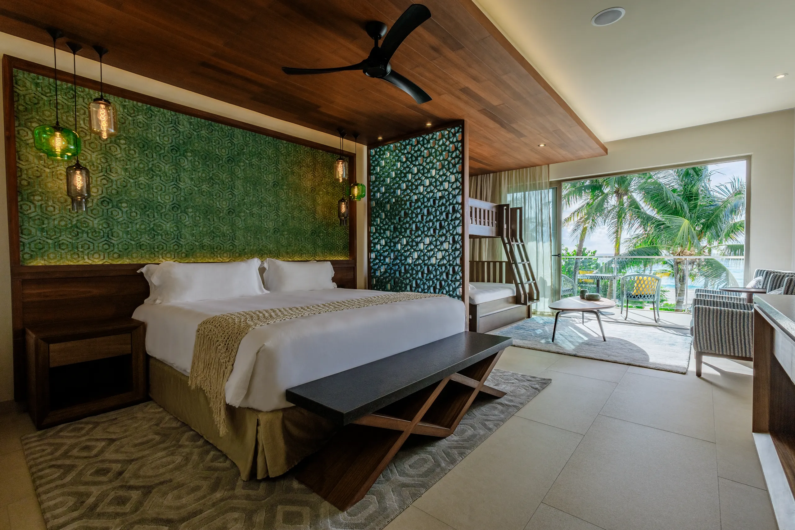 Stylish family suite with king bed, bunk beds and balcony sea view.