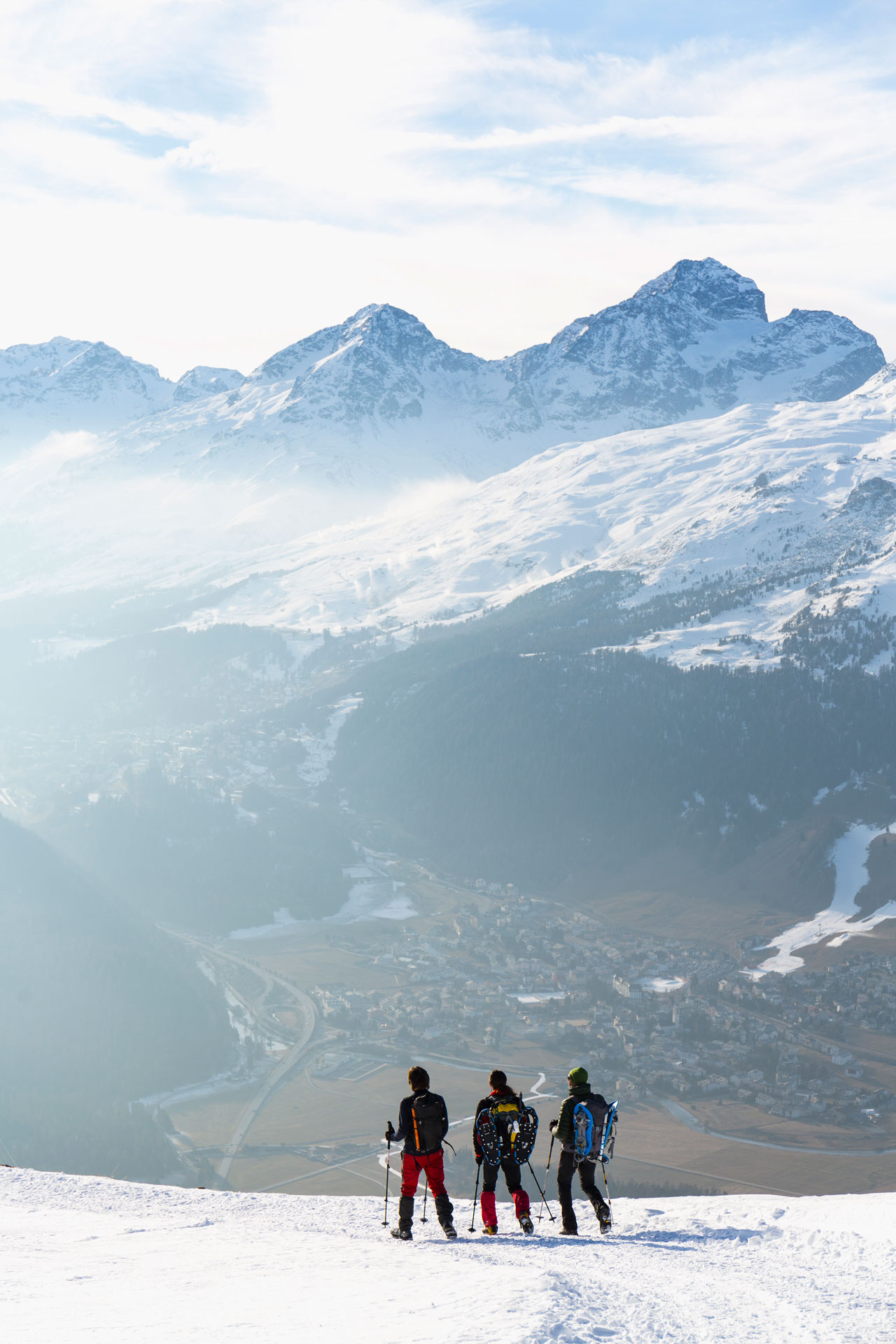 Hikers walking on snow covered road in high mountain
